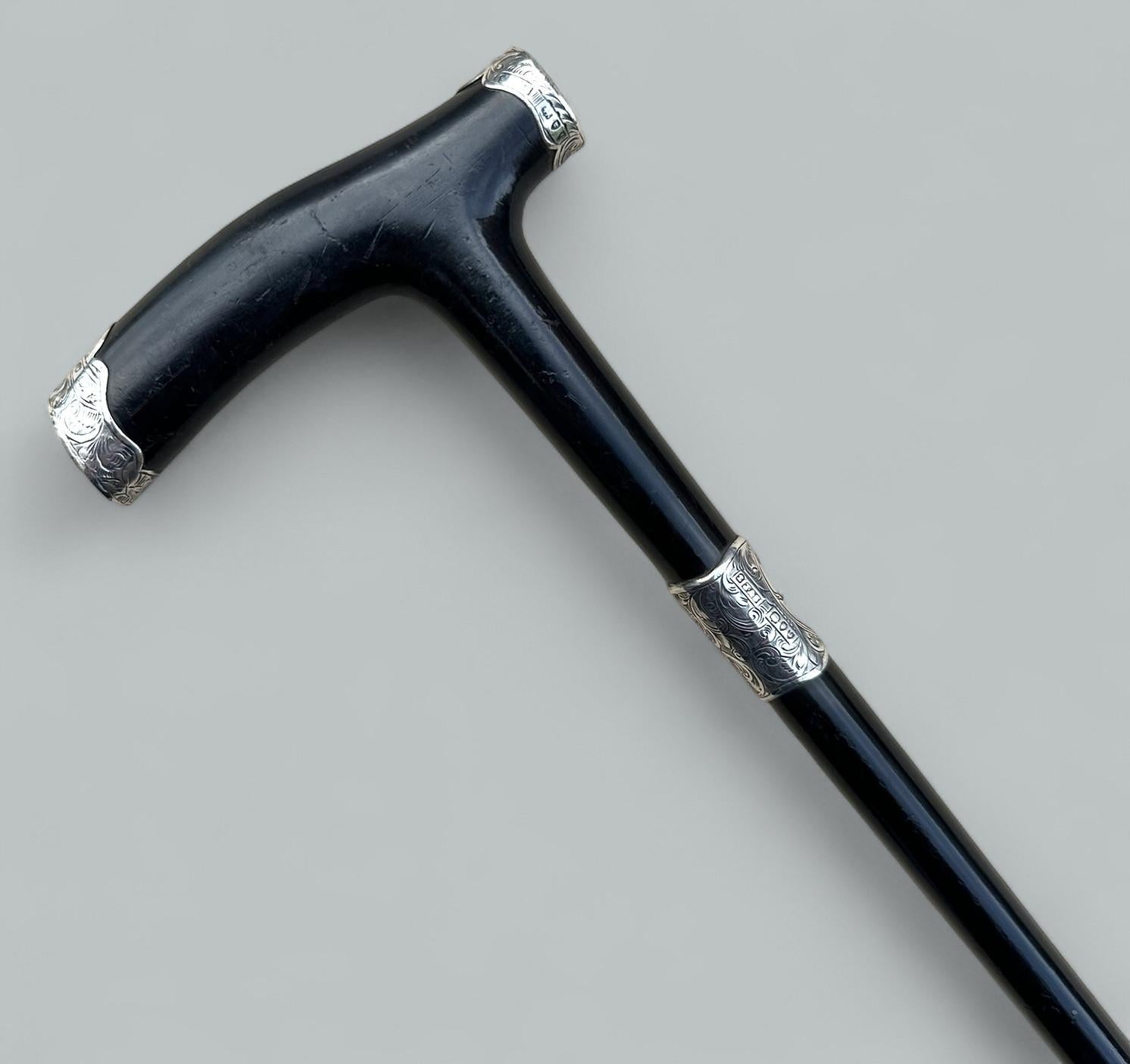 Bastón o Bastón de Vestir Inglés para Señoras o Caballeros, de gran calidad y diseño, último cuarto del Siglo XIX. 

Plata de ley Marca de: James Scholes, fechada en 1897.  

La empuñadura de madera en forma de tau está montada en ambos extremos con