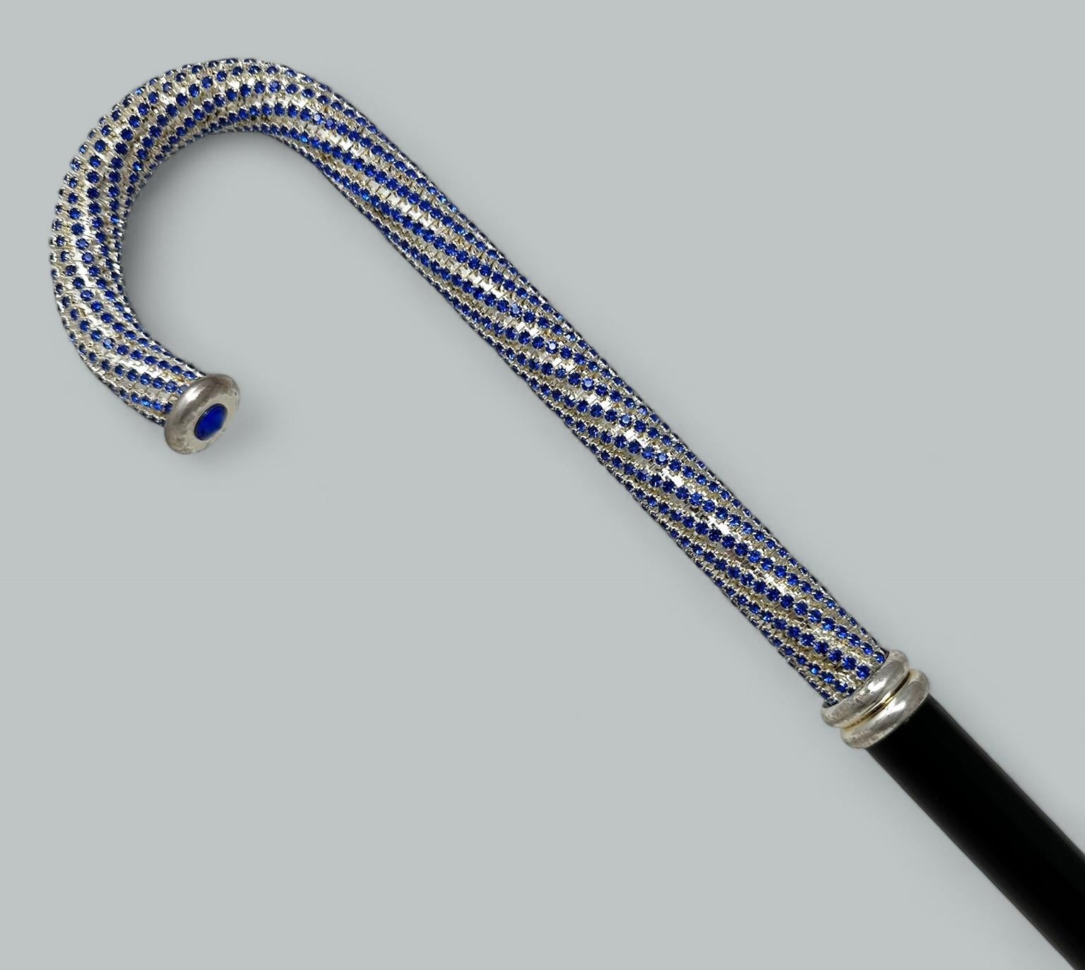 Elegante bastón de dama o caballero de madera maciza ebonizada pulida y plata de ley, con empuñadura tradicional en forma de báculo de estilo Art Nouveau, de origen francés o inglés, con incrustaciones de cristal azul modelado al estilo Swarovski