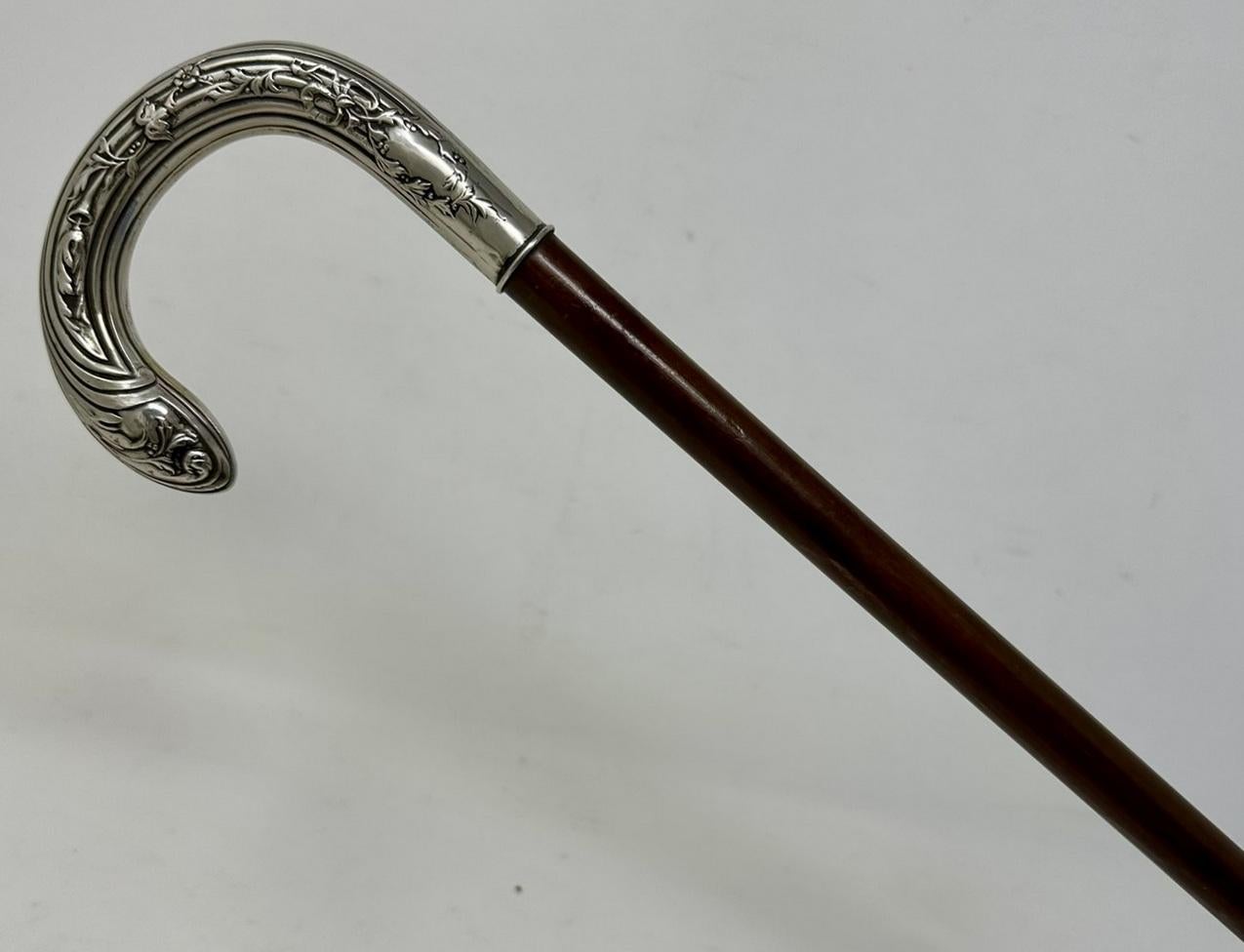 Stylish Solid Polished Dark Malacca Wood and Sterling Silver Lady’s or Gentleman’s Walking Stick with Traditional ornately cast Crook shaped handle in Art Nouveau style, of French or English origin, complete with its original bi-metal polished