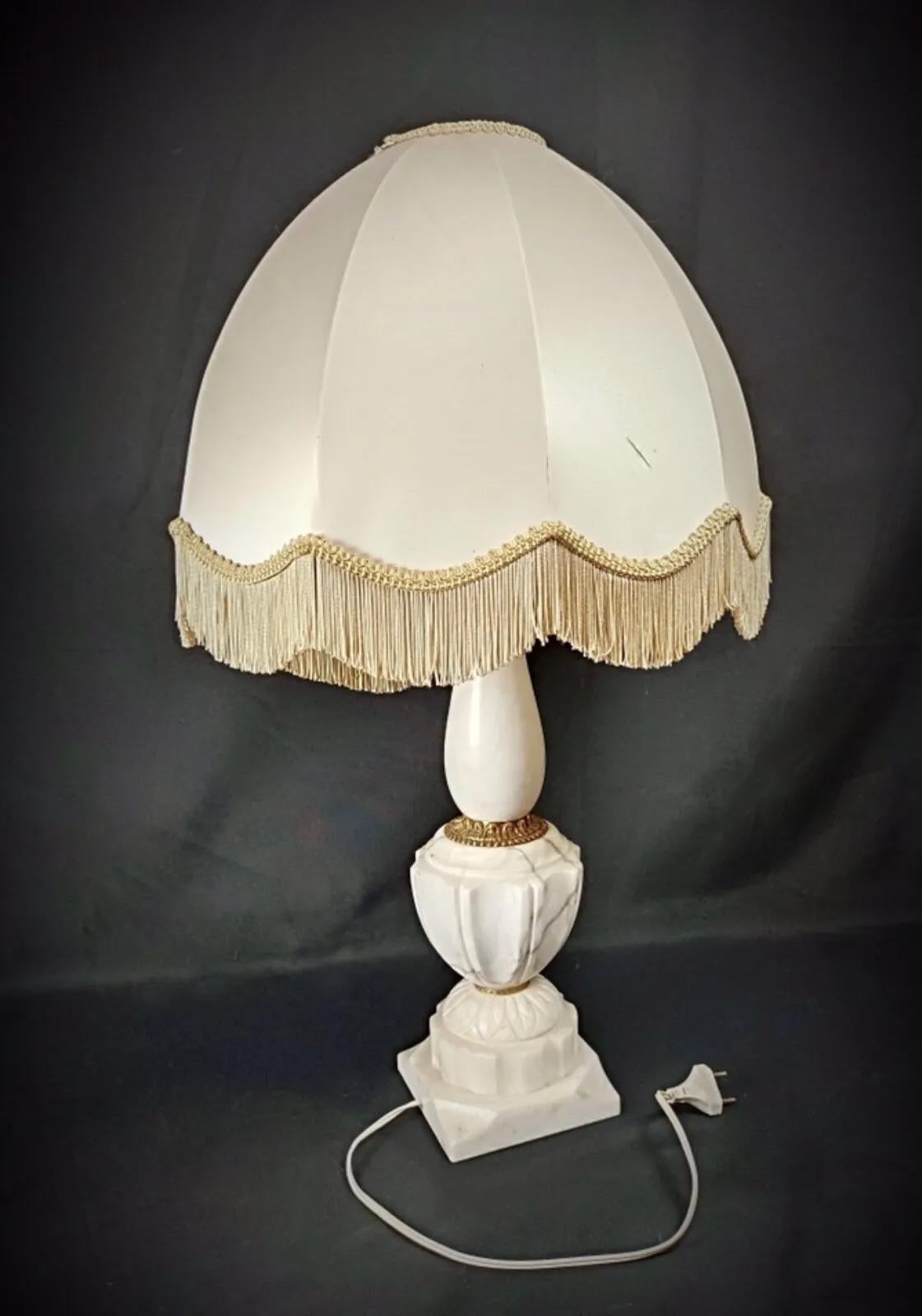 Condition: Good
Comments: The lamp is in working condition, though the electrical wiring does not meet modern standards. The alabaster and brass lamp base is in good condition, with a few minor chips in some areas. The lampshade has small stains,