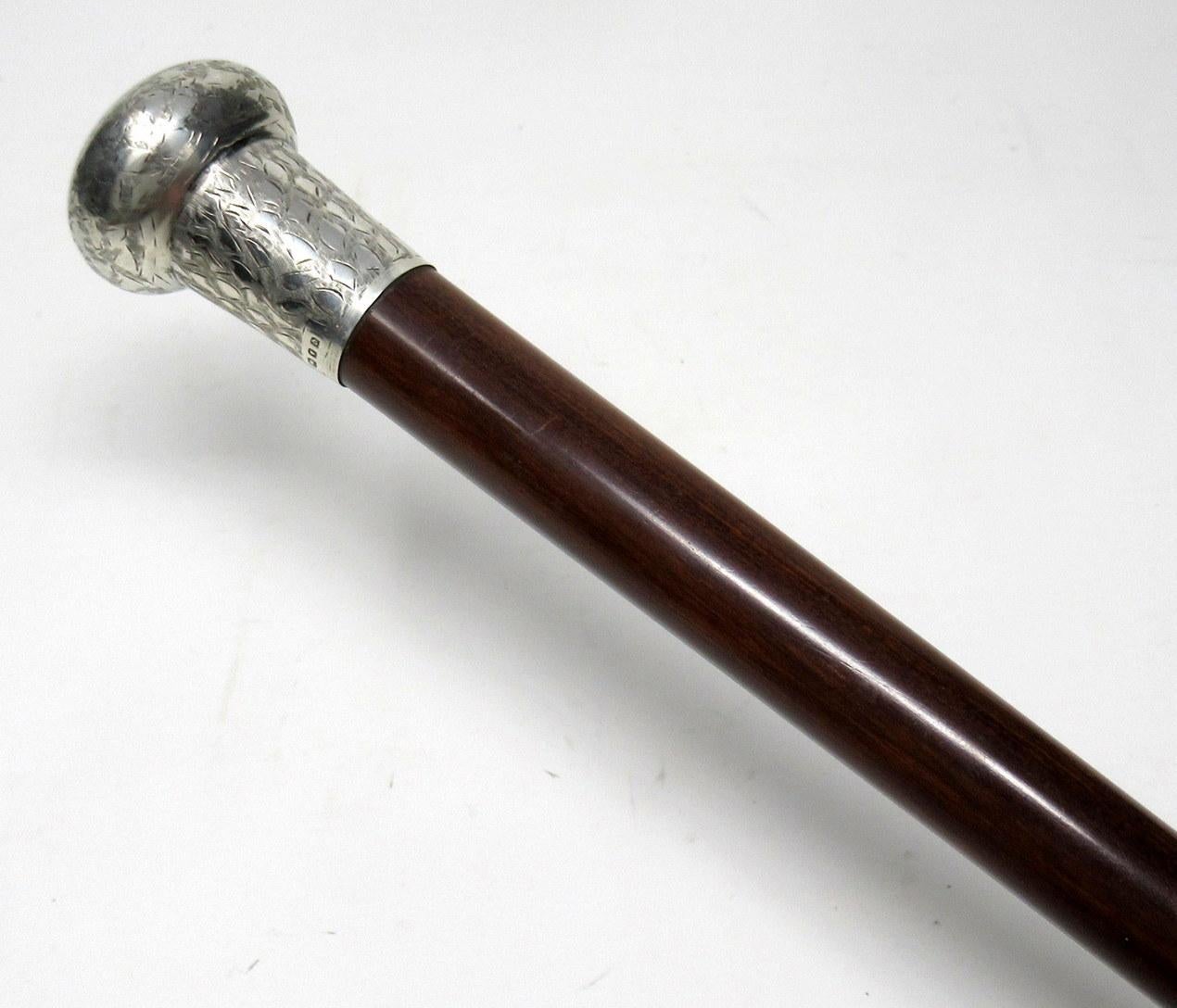 Fine Quality Dark Brown Highly Polished Malacca Walking Cane with Embossed Silver Mount, early Twentieth Century. 

The embossed silver knopped grip above a tapering malacca shaft with later polished brass ferrule. 

Silver makers mark of TD for