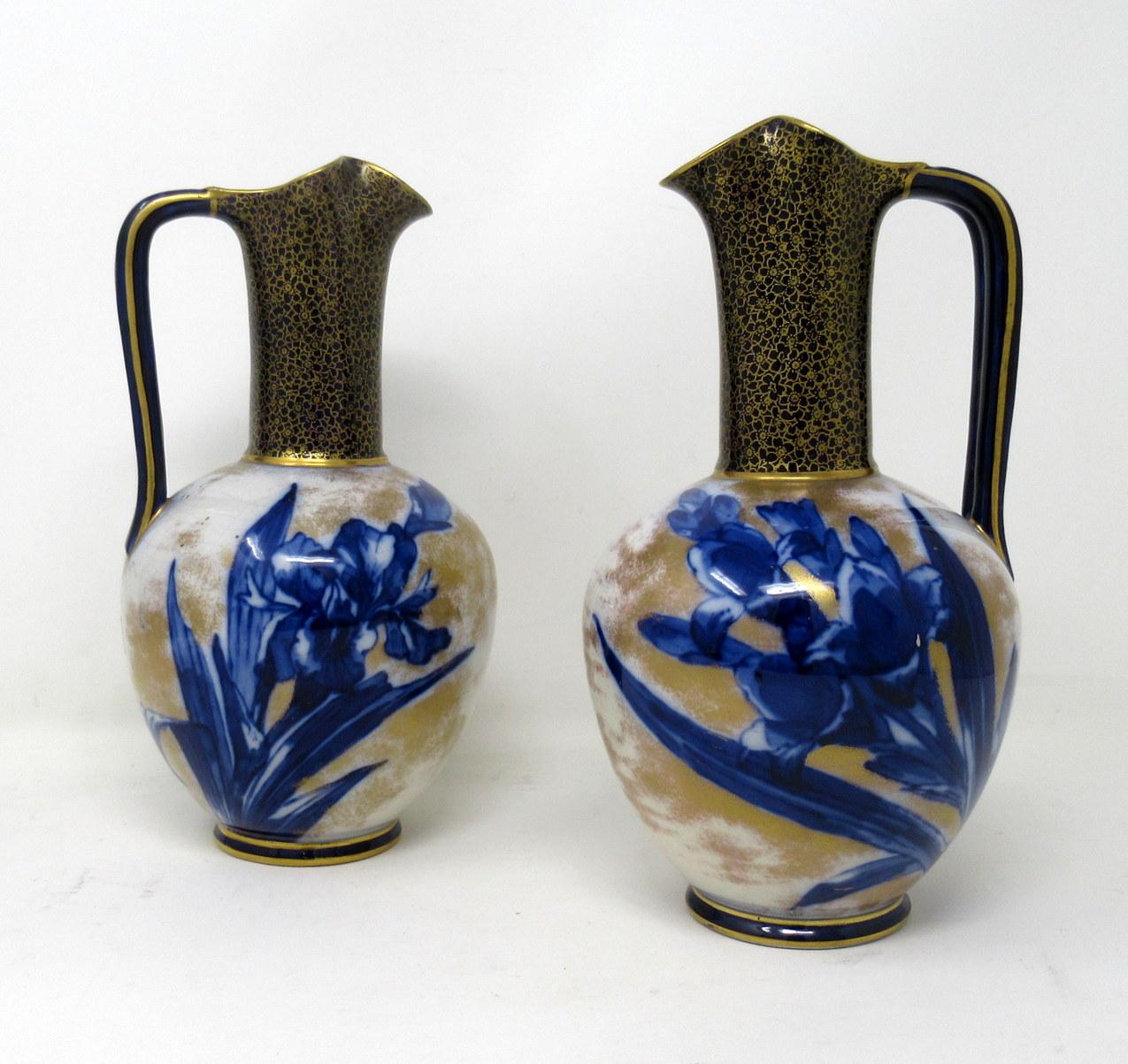 Stylish identical pair of English Porcelain single handle ewers or vases by Famous English Pottery Maker Royal Doulton Burslem, late 19th century. 

Each ovoid central body superbly decorated with flo-blue Iris Flowers on an off-white ground, the