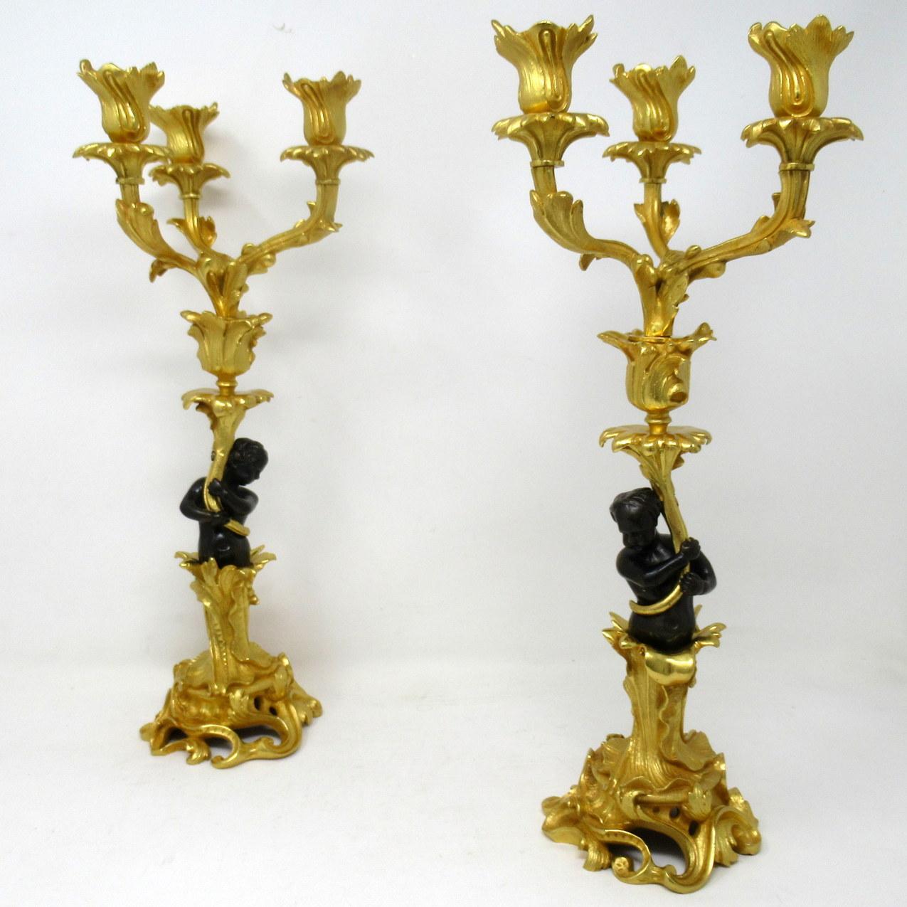 A fine pair of stylish and imposing French ormolu and patinated bronze three-light table or mantel (fireplace) candelabras or single light candlesticks of outstanding quality, mid to late 19th century.

Each with a central standing solid bronze