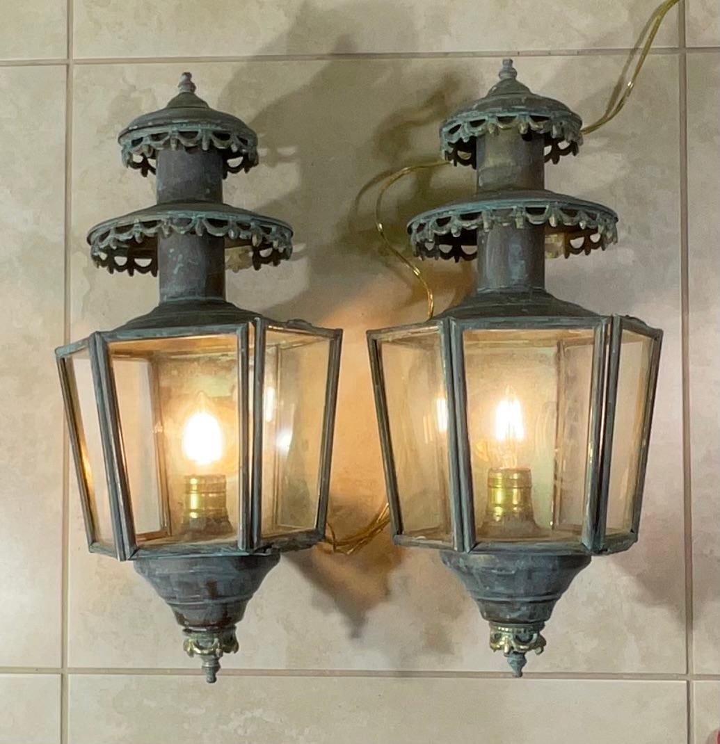 La vente porte sur une magnifique et rare paire de lanternes murales extérieures en laiton massif (également connues sous le nom d'appliques), de style ancien ou vintage. Ces luminaires dégagent une élégance intemporelle et un charme historique, ce