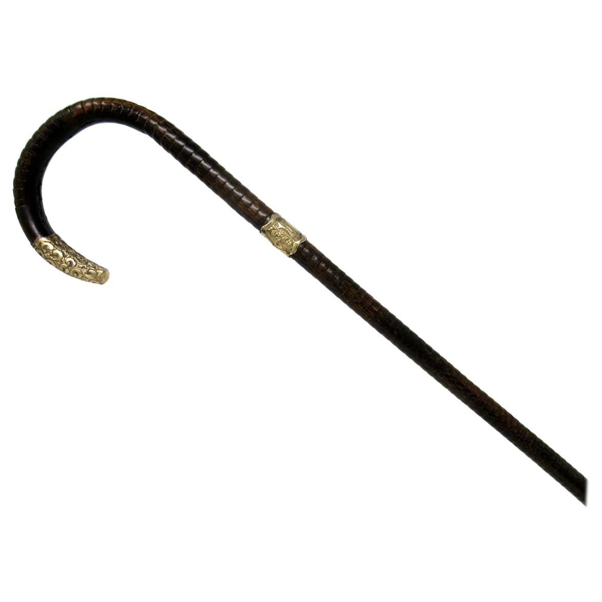 Fine quality polished stepped partridge wood traditional crook handled ladies or gentleman’s walking cane with highly decorative embossed eighteen carat gold-plated mount and matching collar with a shield shaped cartouche, last quarter of the 19th