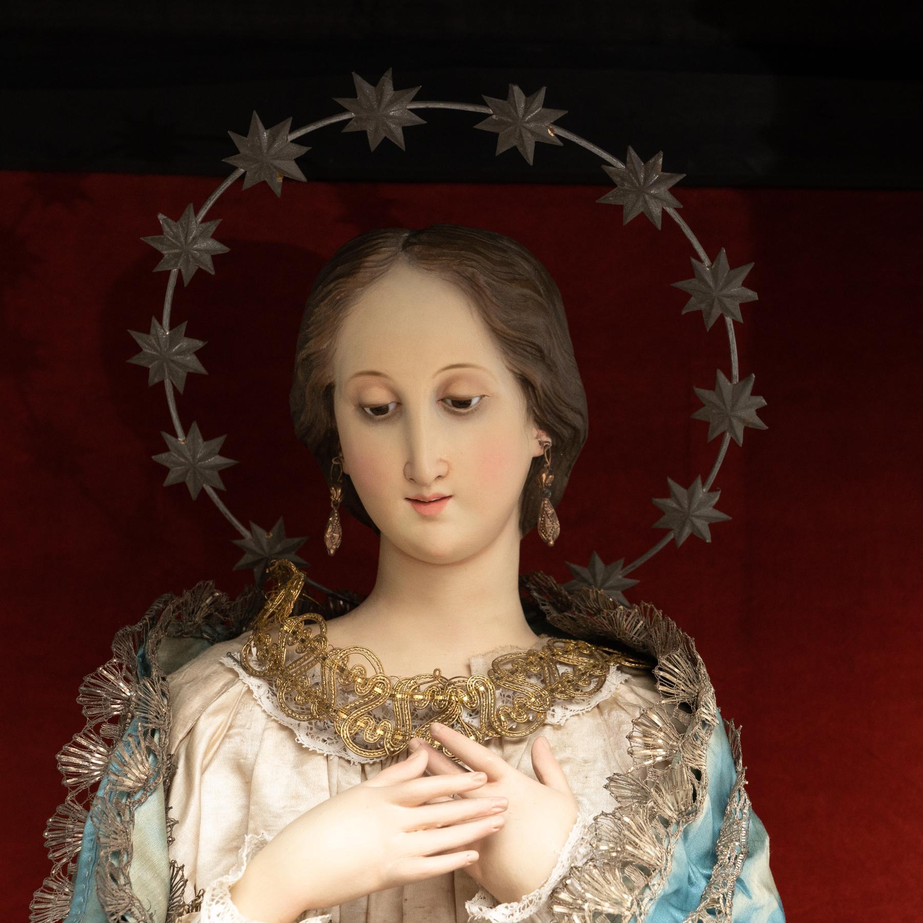 Antique cabinet with a slide glass door containing an antique plaster sculpture of a virgin, dressed with hand-tailored clothes.  Manufactured by unknown artist in Spain, circa 1940.  In original condition, with minor wear consistent with age and