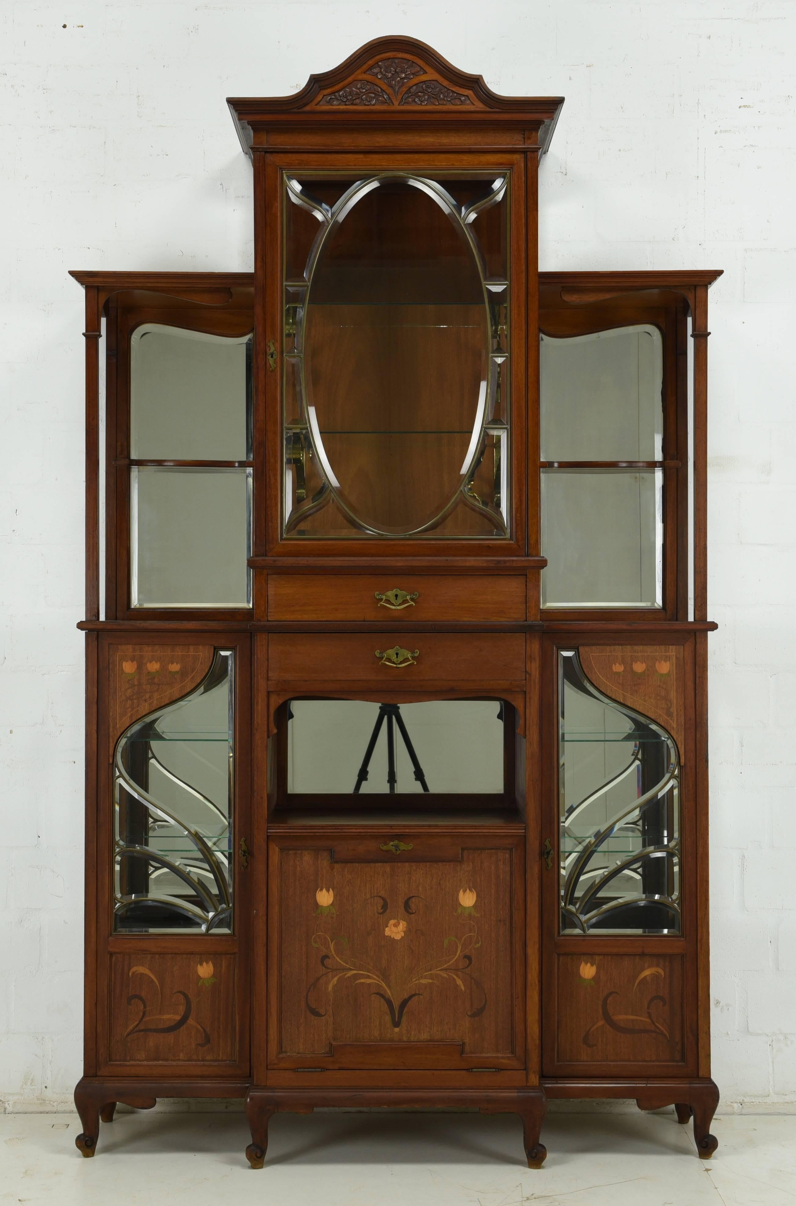 An antique Art Nouveau from circa 1915 made of mahogany. This masterpiece was manufactured with a very high quality workmanship and complex ornamentations. Big mirrors on both sides and glass walls are perfect for displaying your items. Glass floors