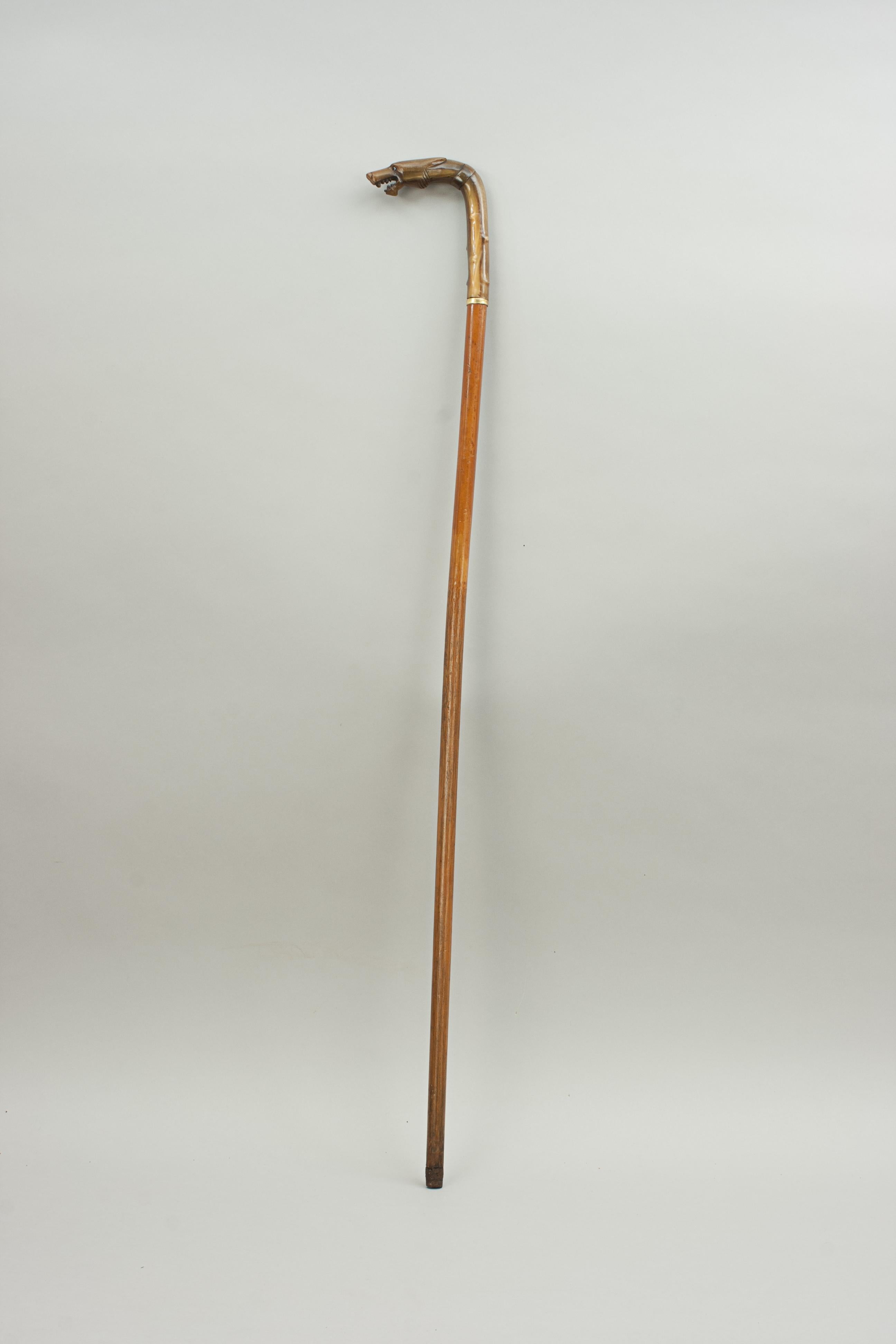 Horn handled wolf head walking stick.
Late 19th century gentleman's walking cane, the handle made from horn, carved and modelled as a wolf's head. The nicely carved head with inset glass eyes and fitted onto a Malacca shaft. The wolf's mouth is