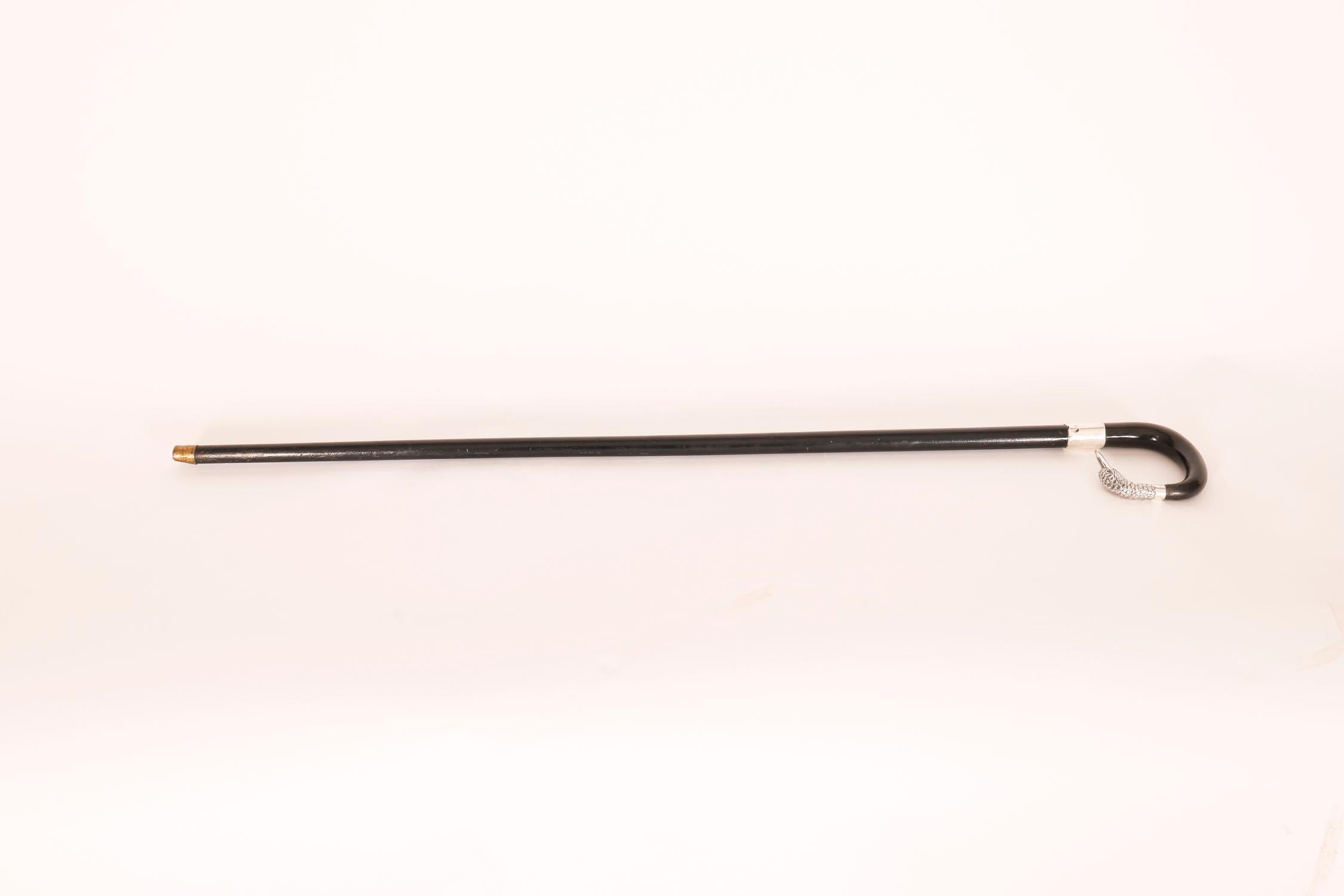 An antique ebony and horn-mounted walking cane, with silver duck head handle and glass eyes, bearing hallmarks for London 1924

This charming walking cane features a finely cast sterling silver duck head crook handle with glass eyes on a ebonized