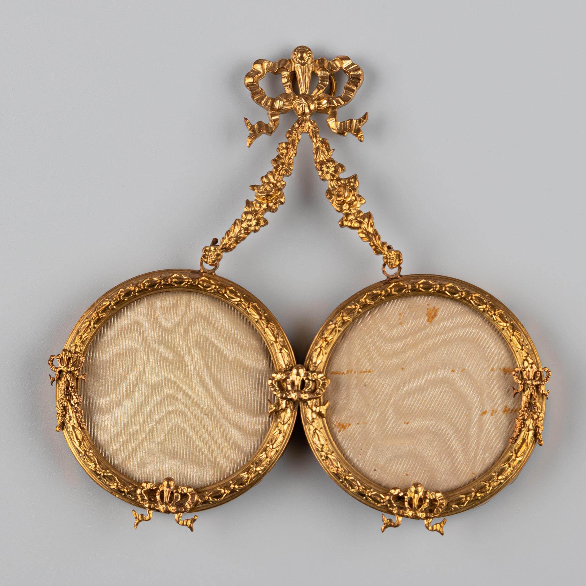 Beautiful double brass picture frame for wall installation, France, circa 1880.
Picture size: 4,5 cm x 4,5 cm.
Hanging ring on the top for wall installation, hidden behind a wonderful bow and flowery ornaments.


