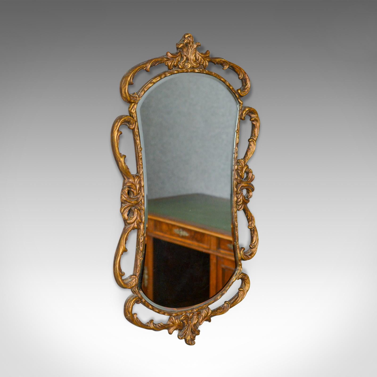 This is an antique wall mirror, an English, Victorian, gilt gesso mirror in the classical taste dating to the latter part of the 19th century, circa 1880.

Typically Victorian elaborate and elegant design
Gilt gesso frame featuring scrolls and