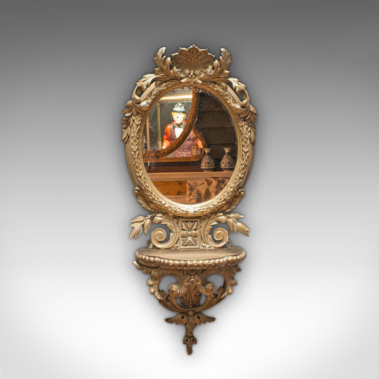 This is an antique wall mirror. A French, gilt gesso oval mirror with ornate frame, dating to the early Victorian period, circa 1850.

Superb detail and appealing hues
Displaying a desirable aged patina
Gilt gesso shows wear commensurate with