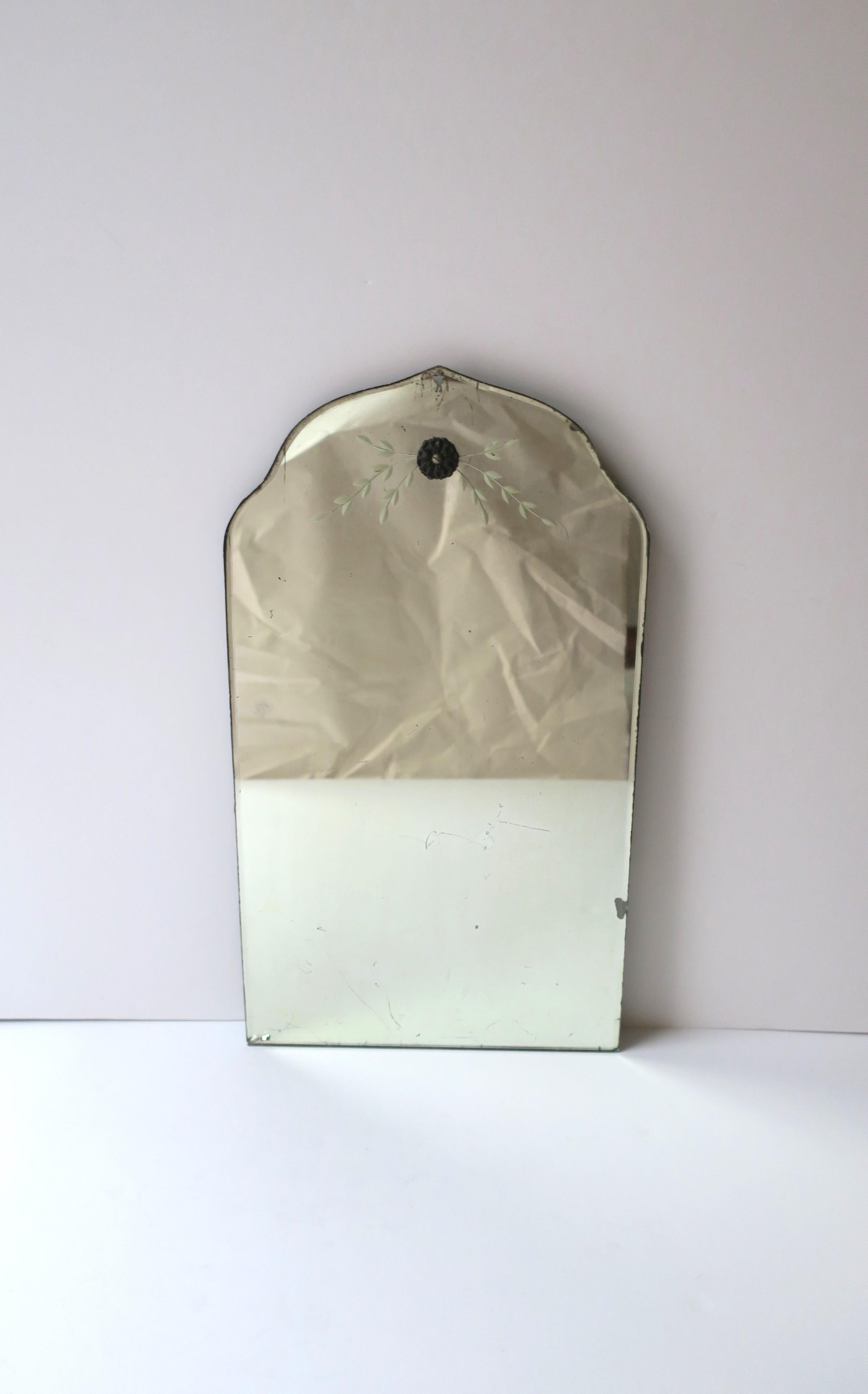 A small antique wall mirror with Moorish design around top edge, circa early-20th century. Mirror has a Moorish design around top edge, metal floweret and etched sprayed leaf design at top center of mirrored glass. A great piece where a small mirror