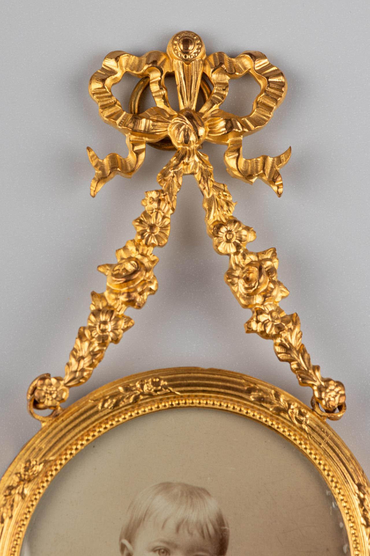 Beautiful brass picture frame for wall installation, France, circa 1880.
Picture size: 4,7 cm x 4,7 cm.
Hanging ring on the top for wall installation, hidden behind a wonderful bow and flowery ornaments.
With Photograph of that time.

