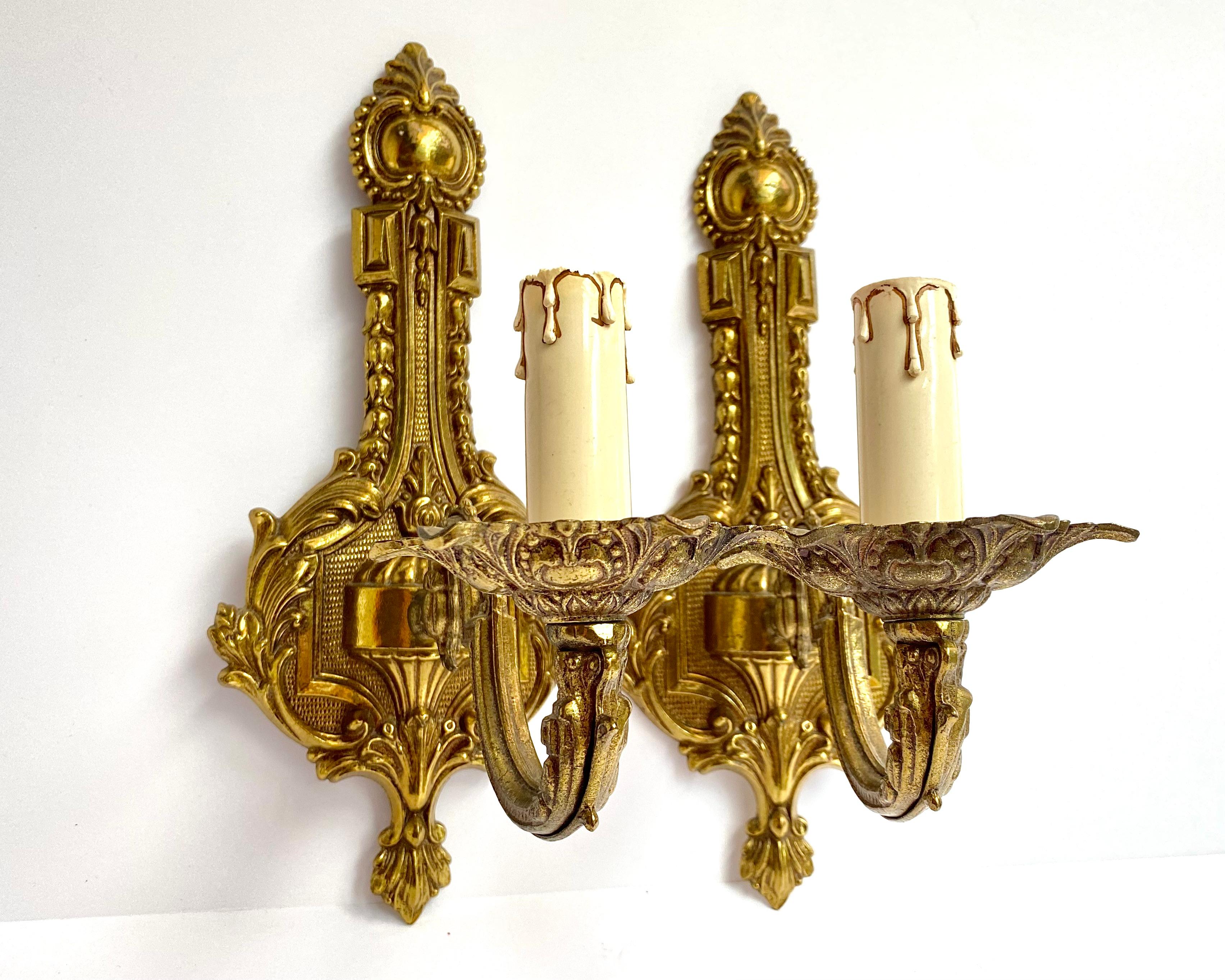 Magnificent Single-Arm brass wall lamps from France imitate classic candleholder.   Circa 1930s.

The design of the lighting fixture contains elements of the Baroque style.

  Decorative details made of cast brass are decorated with