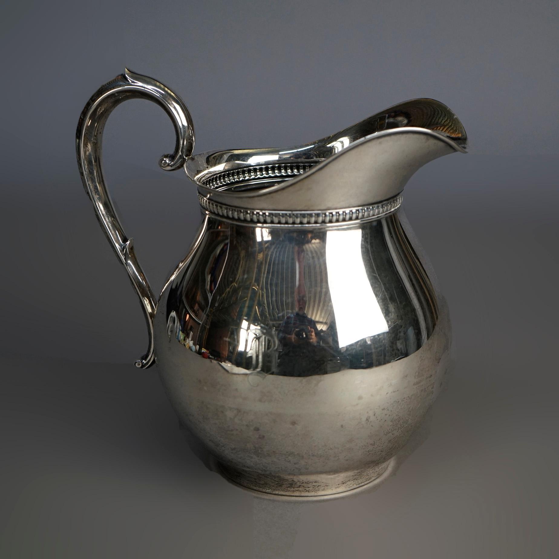 An antique pitcher by Wallace offers sterling silver construction with beaded collar and foliate form handle, maker mark on base as photographed, c1940

Measures- 8''H x 6.25''W x 8.5''D.

Catalogue Note: Ask about DISCOUNTED DELIVERY RATES