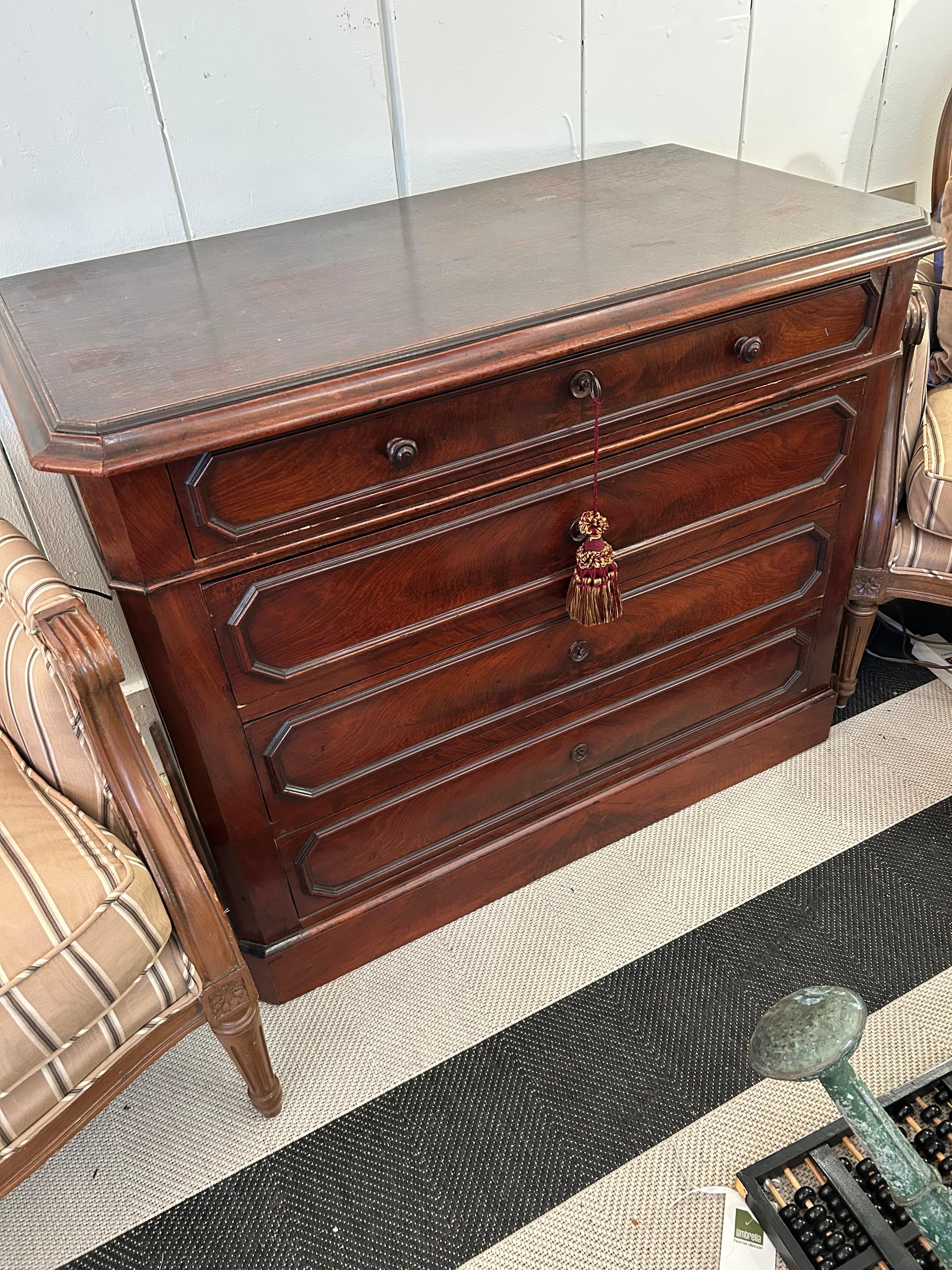 Handsome medium sized walnut commode having 4 drawers and nicely shaped top.  Original key works on bottom 3 drawers.