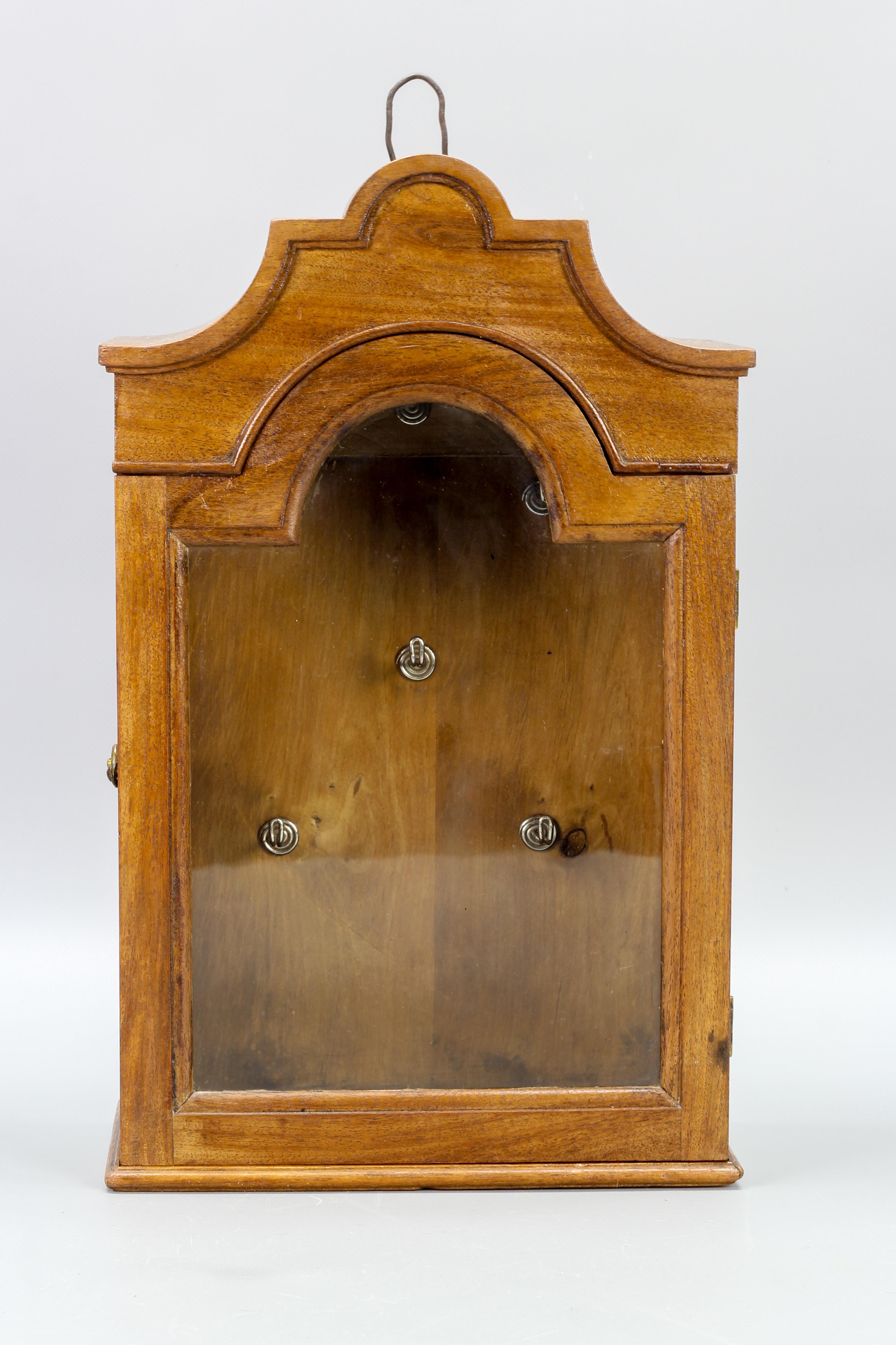 Antique walnut and glass wall hanging key cabinet, ca 1890.
Lovely walnut wall hanging key cabinet with one glazed door opening to reveal six metal hooks for key storage.
Dimensions: height: 38 cm / 14.96 in; width: 24 cm / 9.44 in; depth: 13 cm /