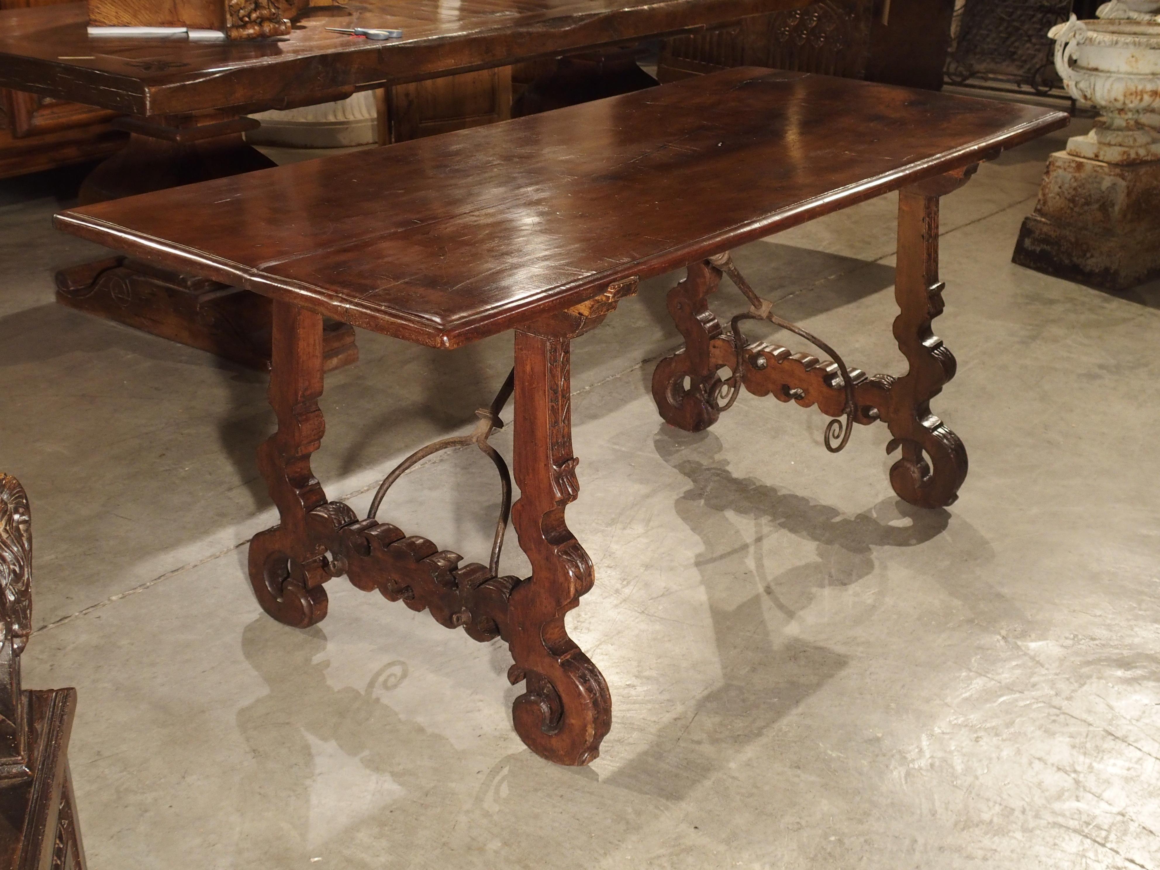 From Spain, this antique walnut wood and iron table has a beautiful single plank top which has remained nice and flat, which is rare. There is ample room at either end of the table to sit comfortably as well as on the sides of the table. The highly