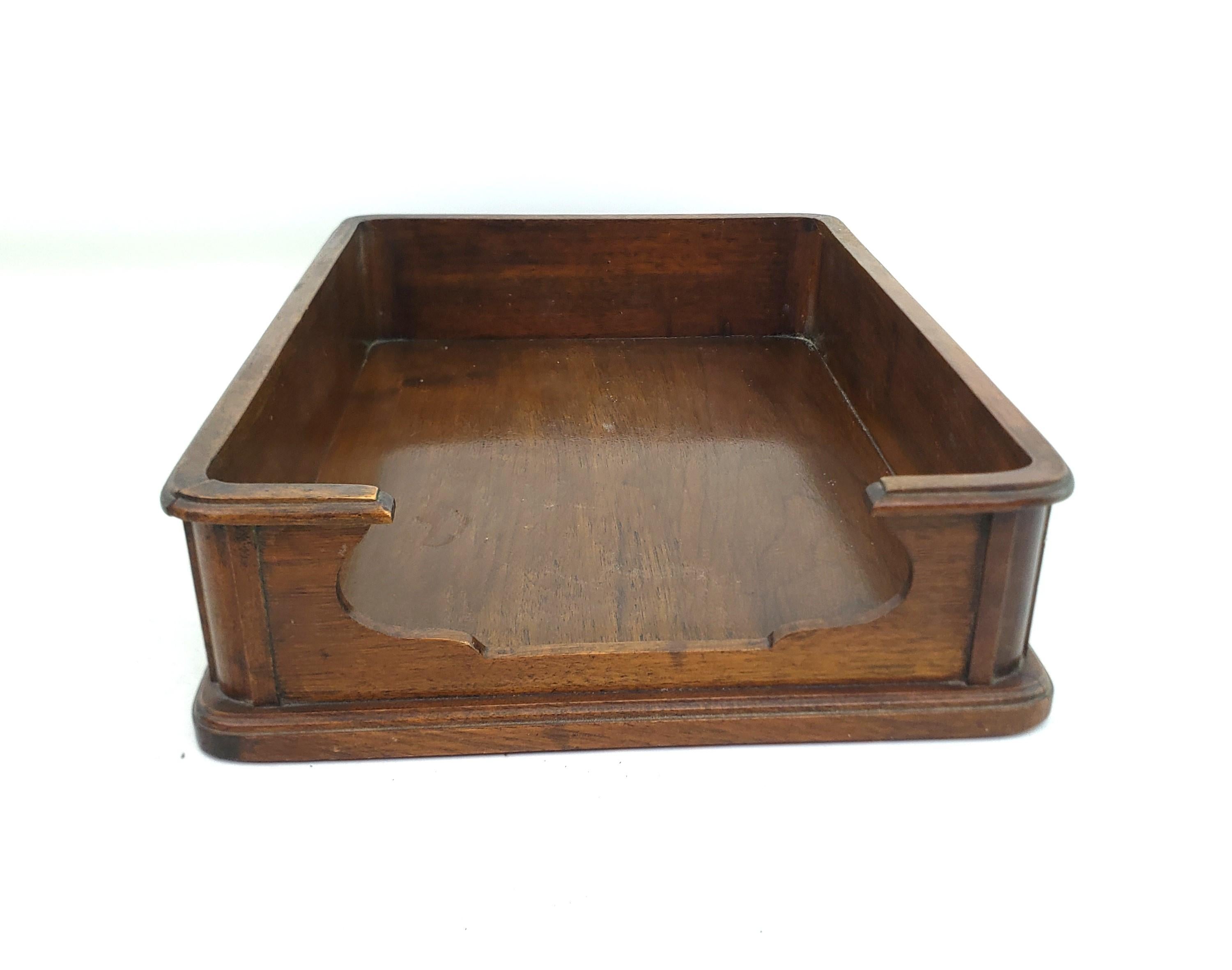 This antique executive desk tray has no maker's signature, but presumed to have originated from England and date to approximately 1920 and done in the period style. The holder is constructed of walnut with a raised top rail and stepped base with