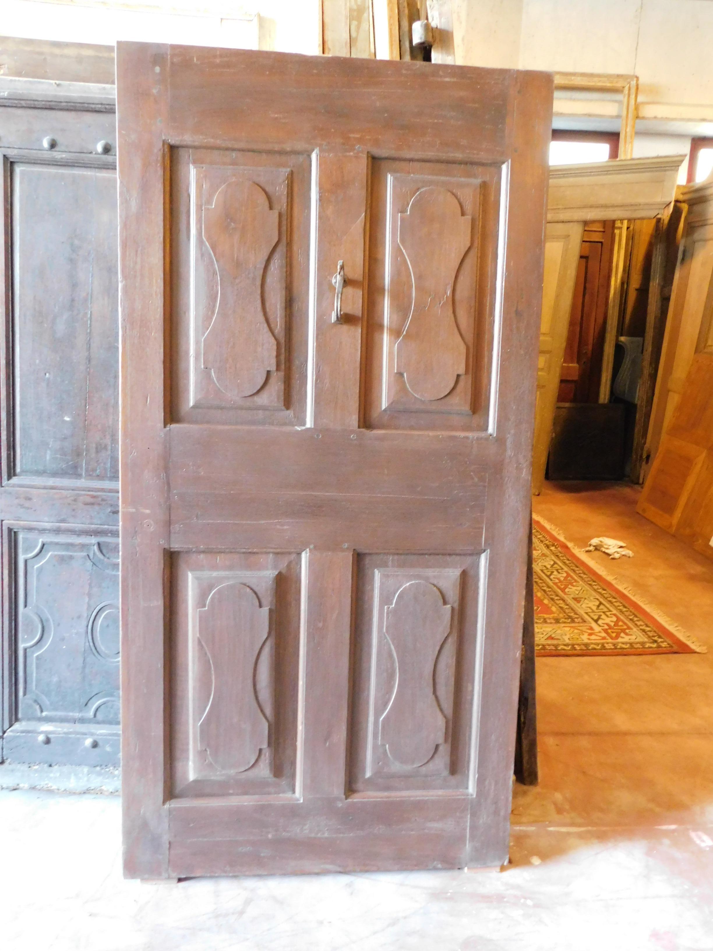 Ancient entrance door in dark walnut, with 4 sculpted tiles and original door knocker, built in the 19th century, from Northern Italy, in patina with a smooth but very beautiful back and already restored.
Of great presence and in excellent