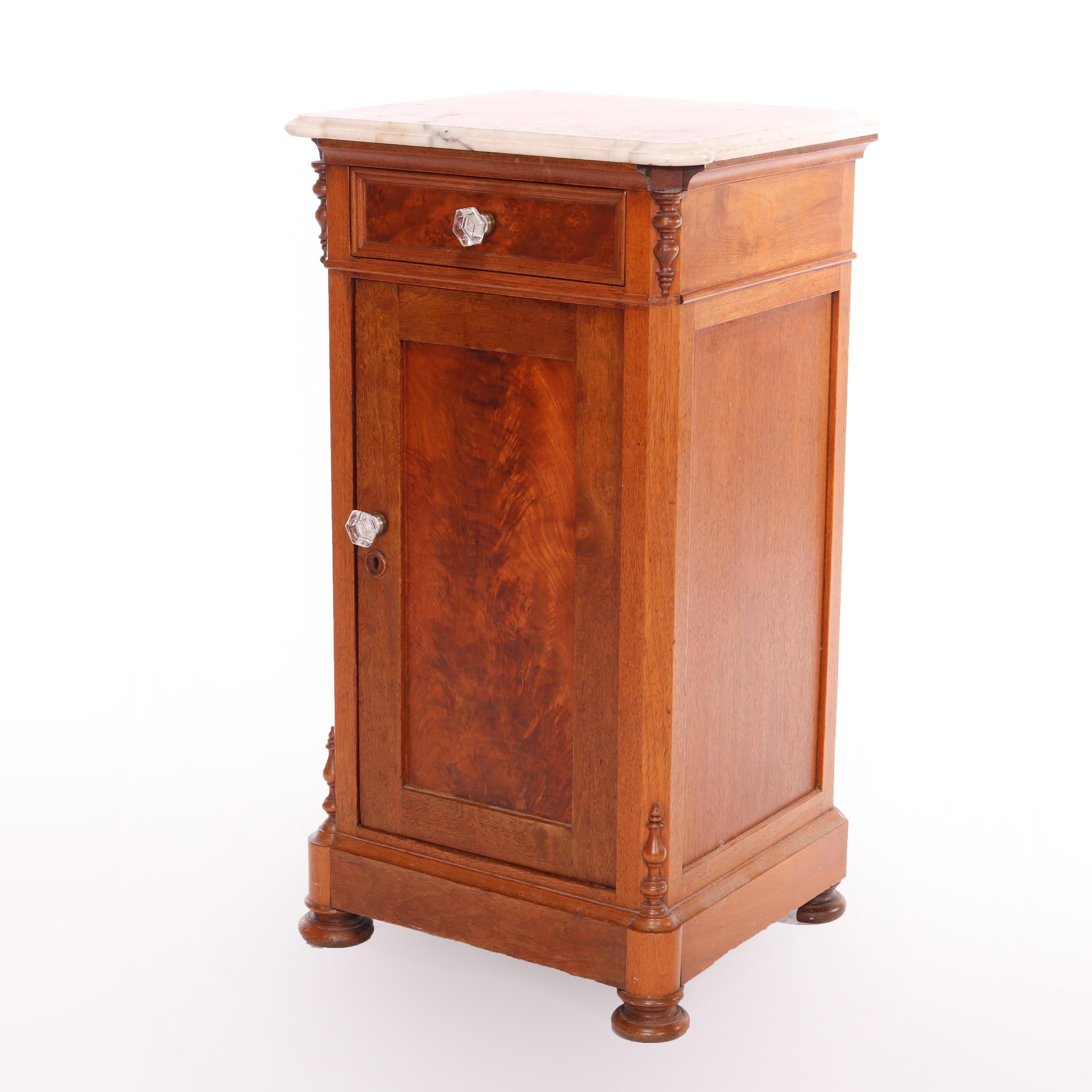 An antique half commode night stand offers beveled marble top over walnut and burl paneled case having upper drawer over lower cabinet with shelved interior, seated on bun feet, c1890

Measures - 31.75'' H x 17.25'' W x 16'' D.