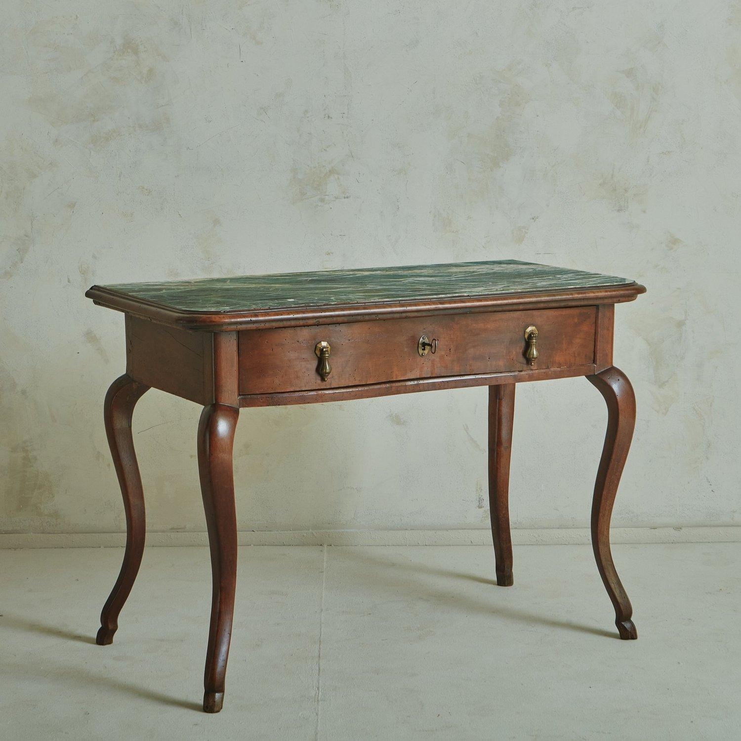 An antique Italian desk constructed with beautifully aged walnut. This piece features an inset Verde Alpi marble tabletop with gorgeous veining in a range of green and cream hues. This table stands on four sabre legs and has one drawer with