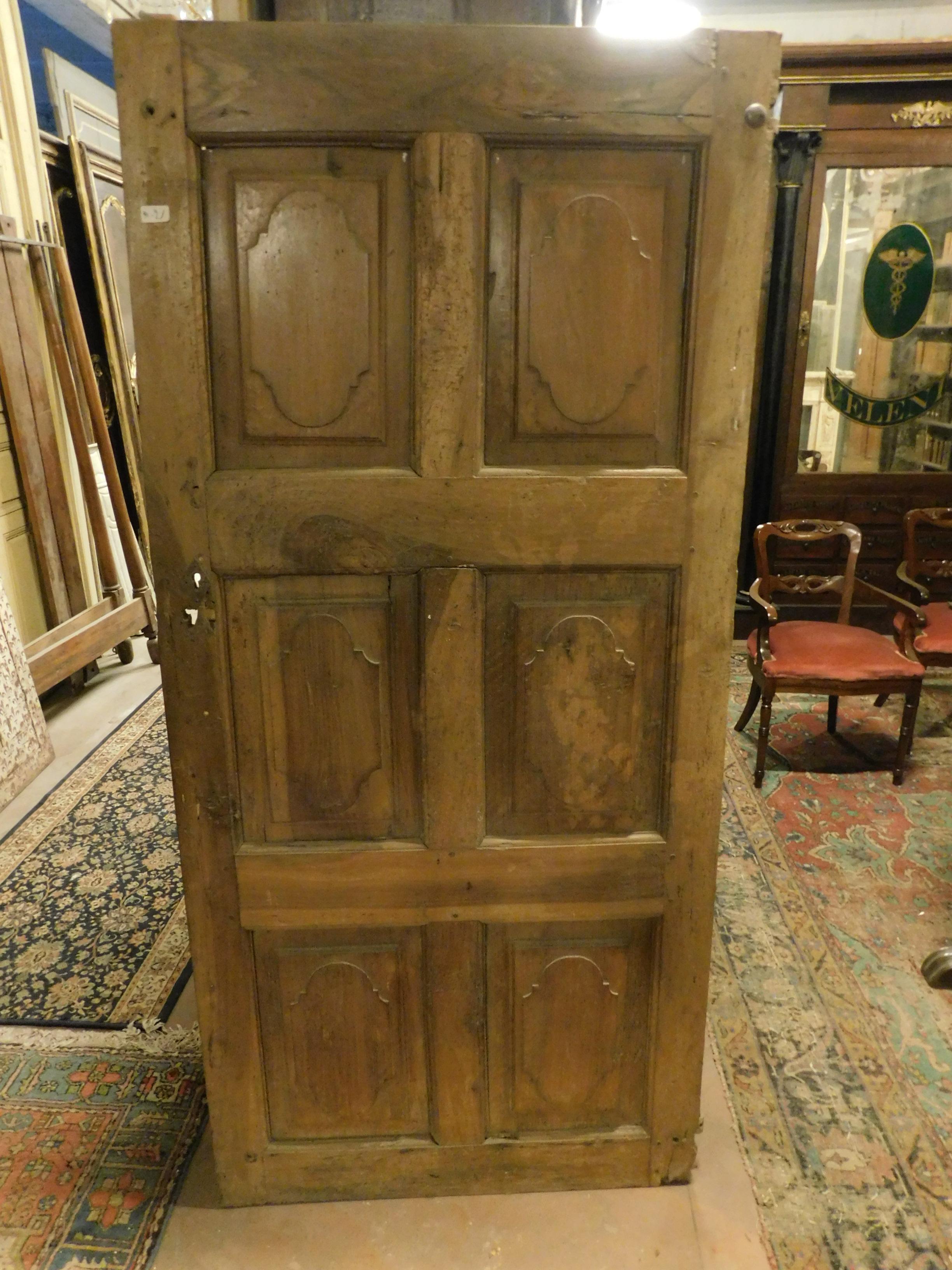 Ancient single door in carved walnut, with six panels and period design, built entirely by hand in the 18th century for a palace in Italy.
It was installed directly on the wall without a frame, in fact it has the original wall irons, to be finished