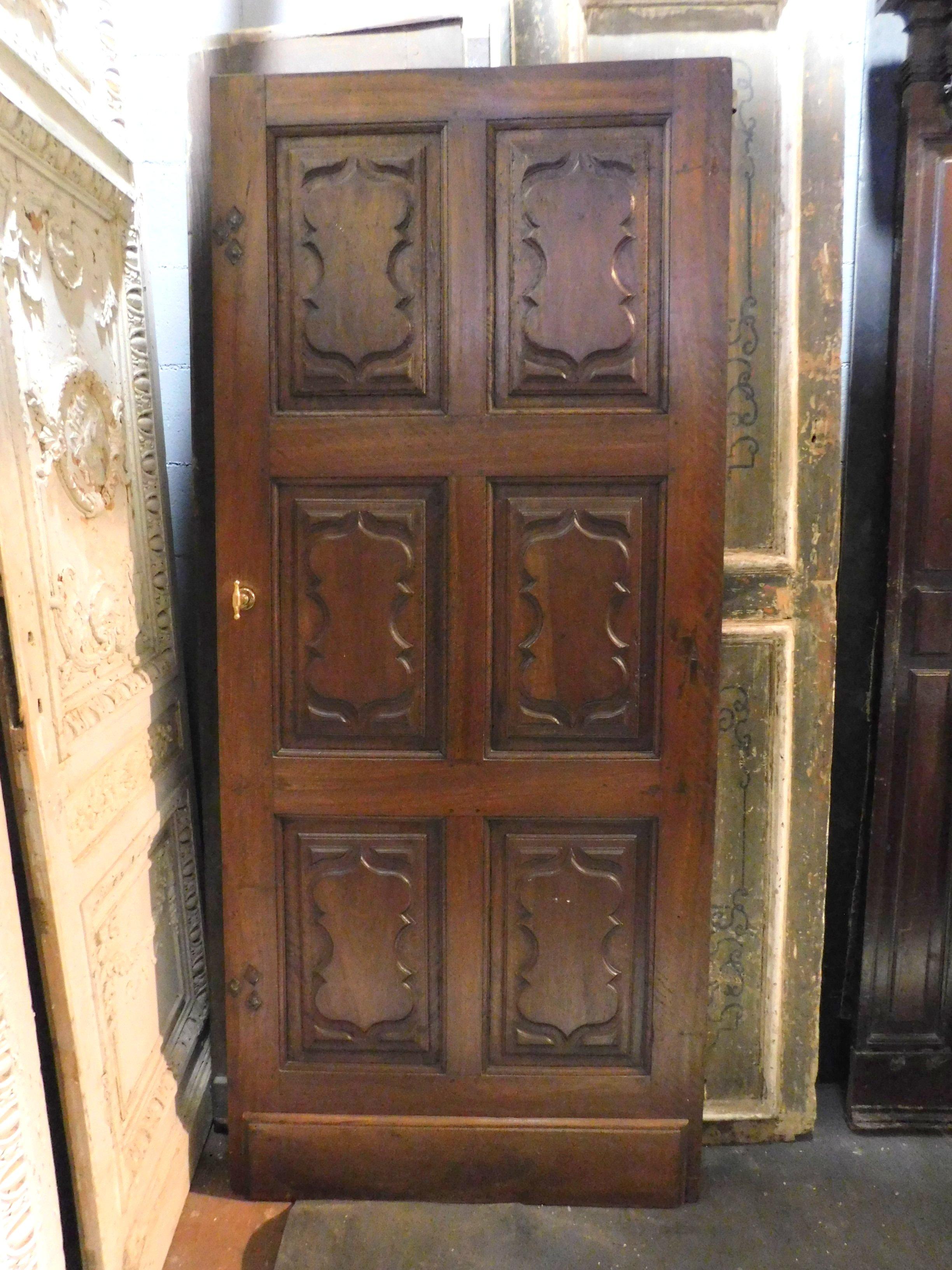 Ancient interior door in maroon walnut, classic and Italian, a material of great value, with six hand-carved panels and baroque tile, built in the 1700s in northern Italy. Classic and massive taste, beautiful also adapted to the modern contrasting