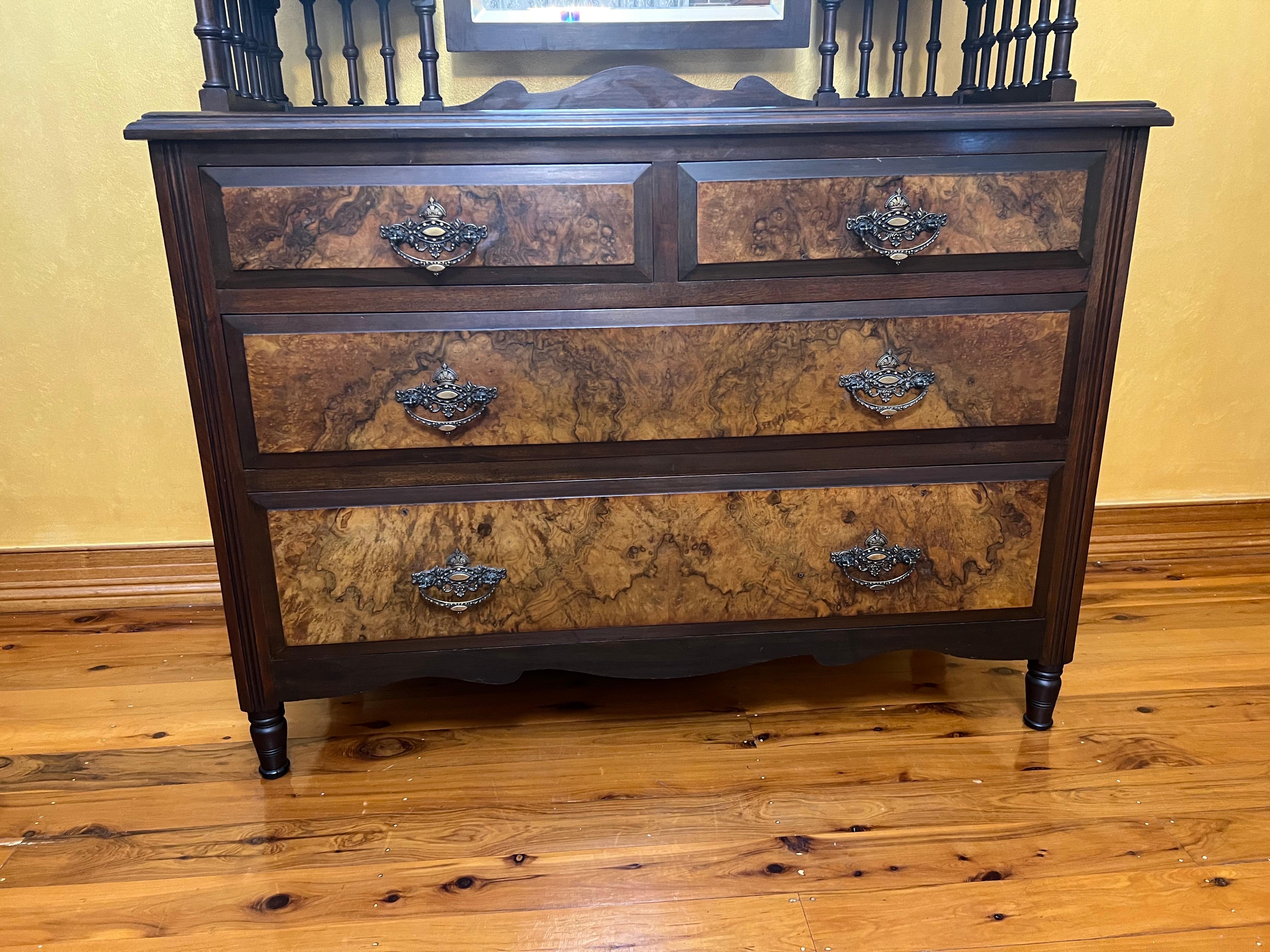 Cast brass drop handles, turned legs, top has two glazed cabinet doors with adjustable bevelled glass mirror, one of the top spindle tips is broken.

circa: 1890

Material: Walnut

Country of Origin: English

Measurements: 185cm high, 111cm