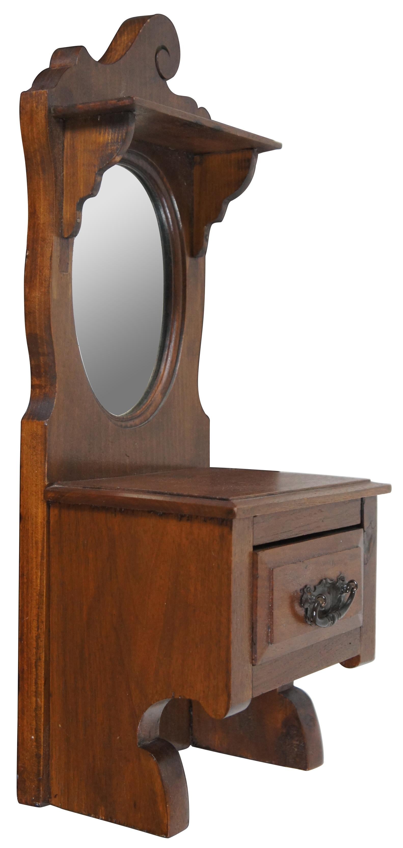 Antique French wall hanging shaving stand. Made from walnut with two shelves, oval mirror, and one drawer.
 