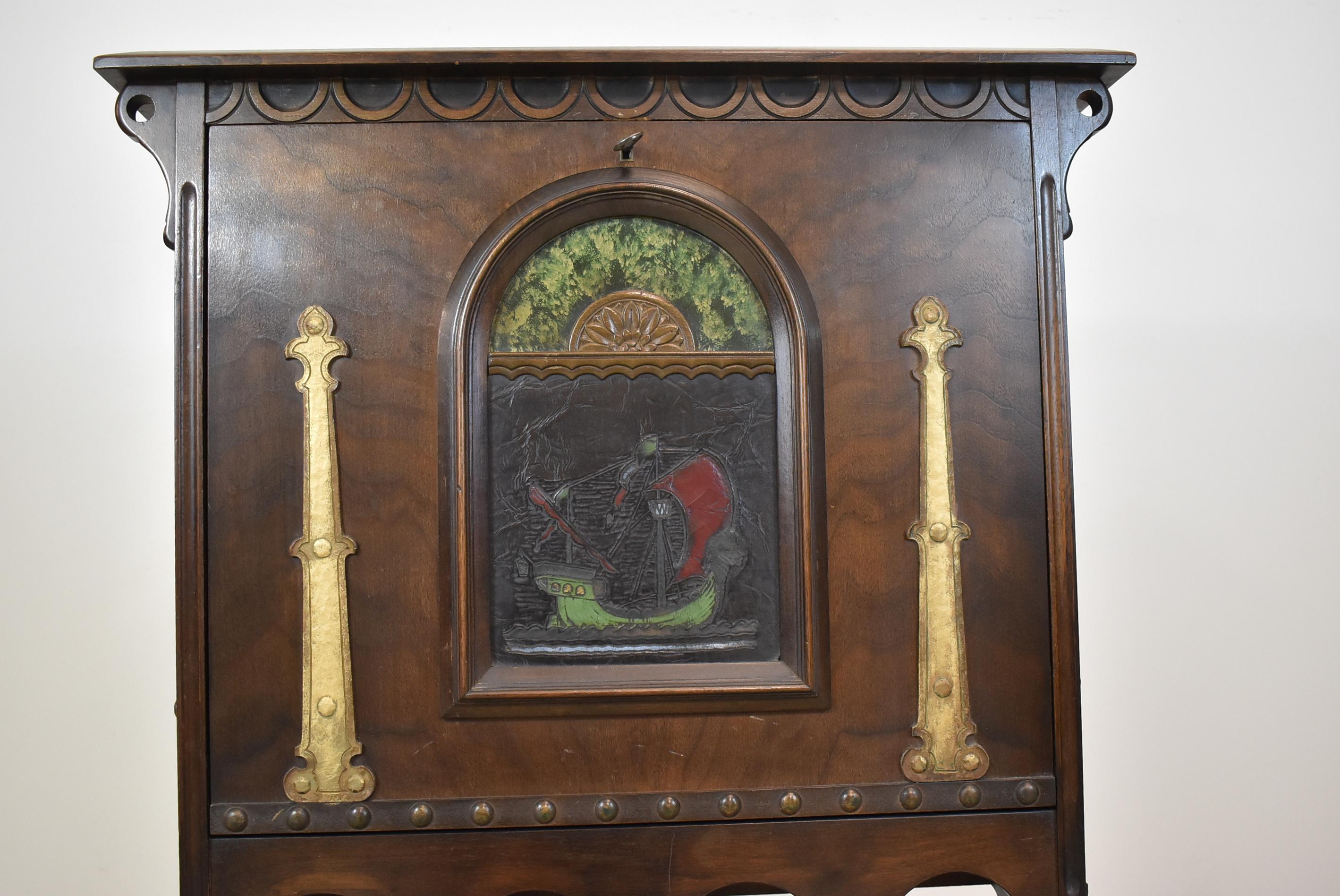 Bureau ancien en noyer, de style néo-gothique, de Hastings Furniture Co., vers les années 1920. Voilier peint à la main sur le devant en cuir. Pieds en fer forgé. Bureau fermant à clé. Mesures : 28