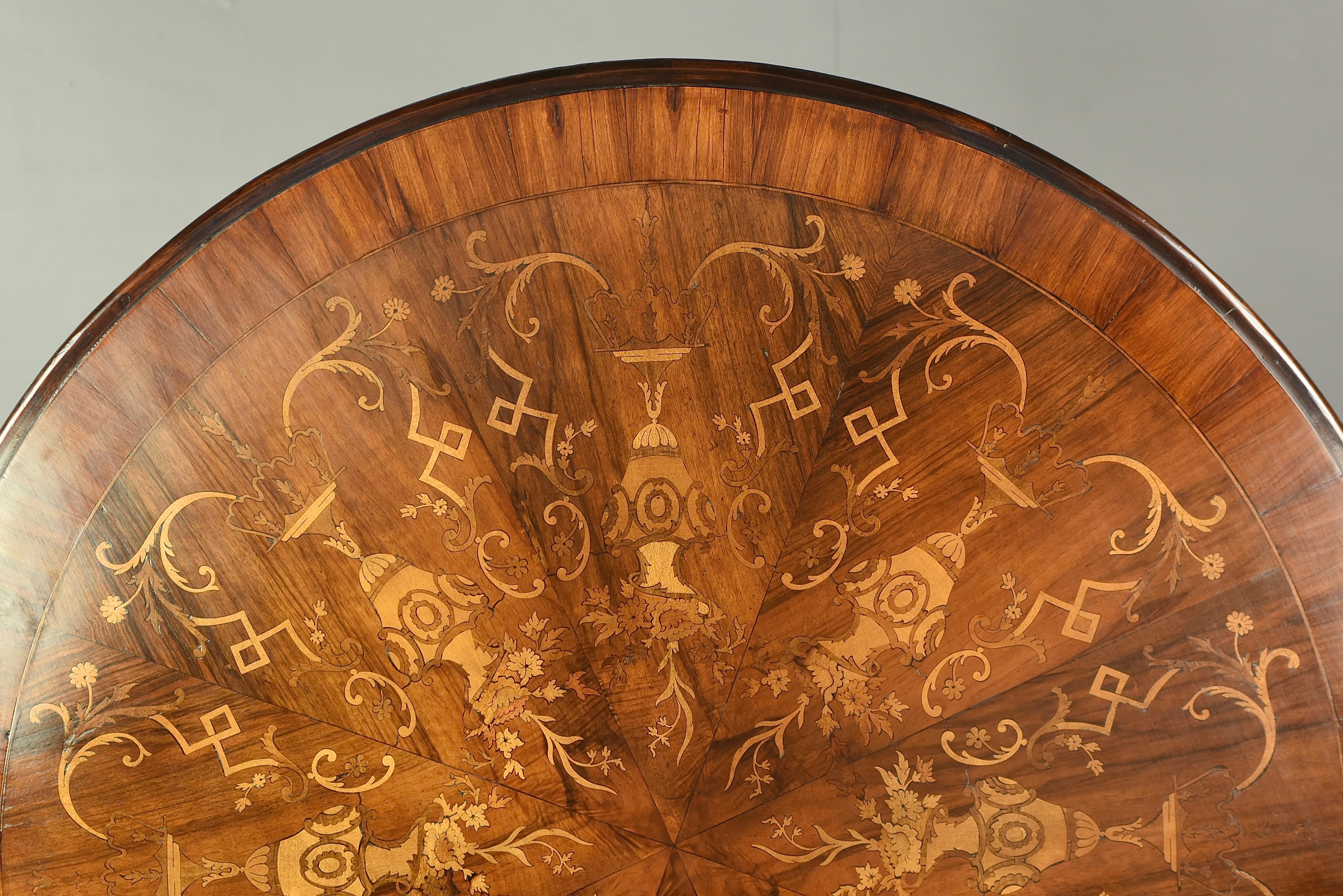 Fine quality inlaid walnut centre table circa 1900 .
The table is in very good condition with a great colour ,it has a diameter of 130 cm and will seat 6 as a dining table .
The top is profusely inlaid with exotic woods depicting vases and floral