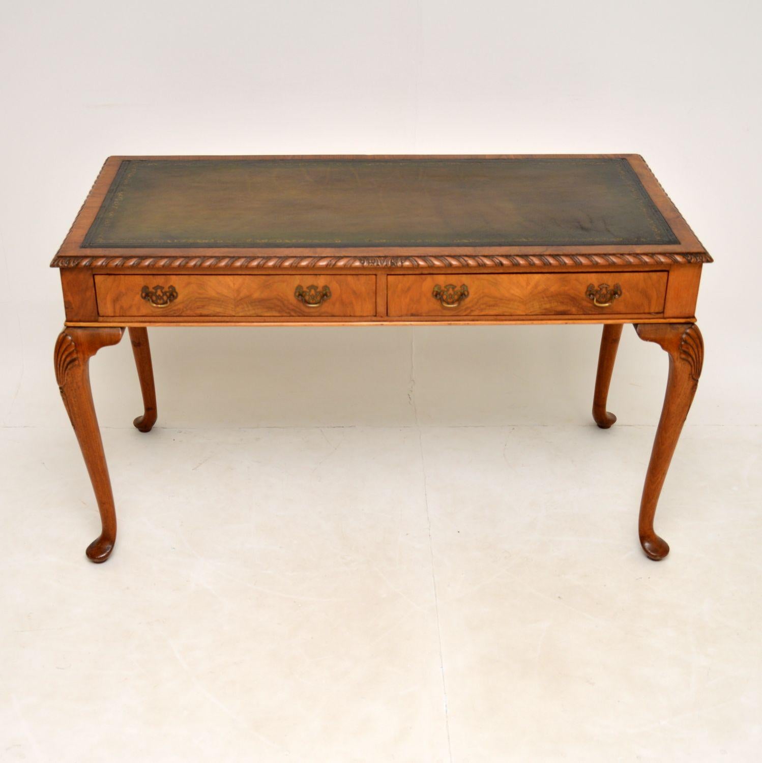 A beautiful and useful antique writing table / desk in walnut. This was made in England, it dates from the 1900-1920 period.

This is extremely well made, its sits on cabriole legs with shell carved knees, and has a gadrooned top edge. The back is