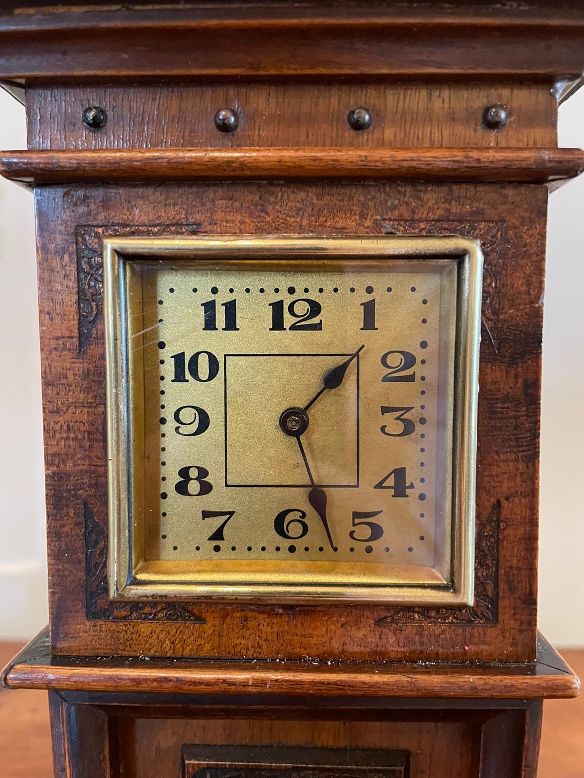 Antique walnut miniature Grandfather clock having an arched top with pierced fretwork carving, brass bezel with original glass, carved corners and quality pierced panel to the front of the moulded edged case. It stands on a shaped plinth with
