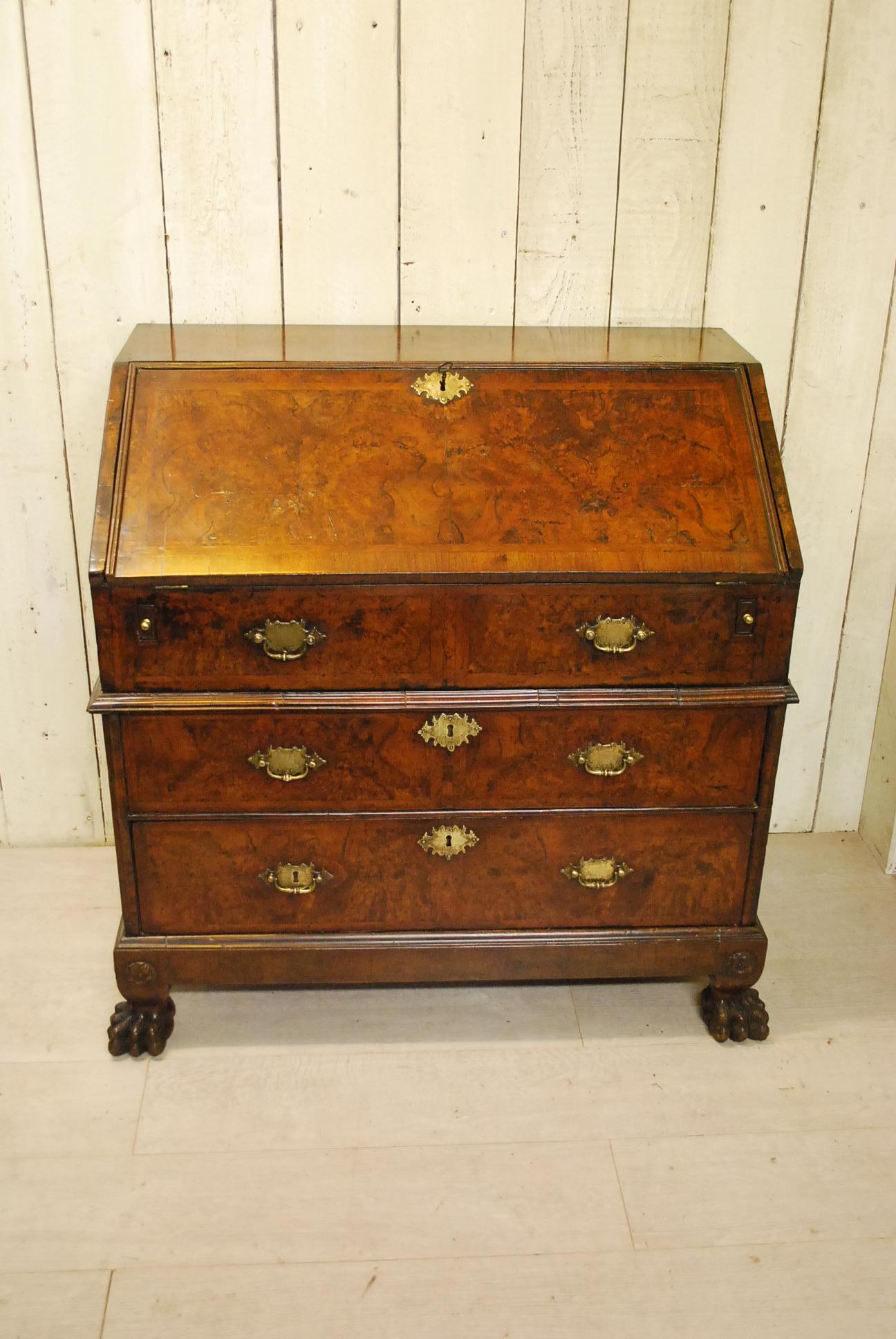 This exquisite English walnut bureau hails from the remarkable Queen Anne period, dating back to approximately 1710. It exudes an air of rarity and uniqueness, boasting an intricate design and exceptional craftsmanship. The bureau is elevated on