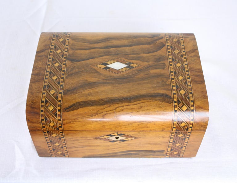 A decorative walnut Tumbridgeware jewelry box with vibrant blue silk interior. Tumbridgeware being characterized as a form of decoratively inlaid woodwork, typically in the form of boxes, that is characteristic of Tumbridge and the spa town of Royal
