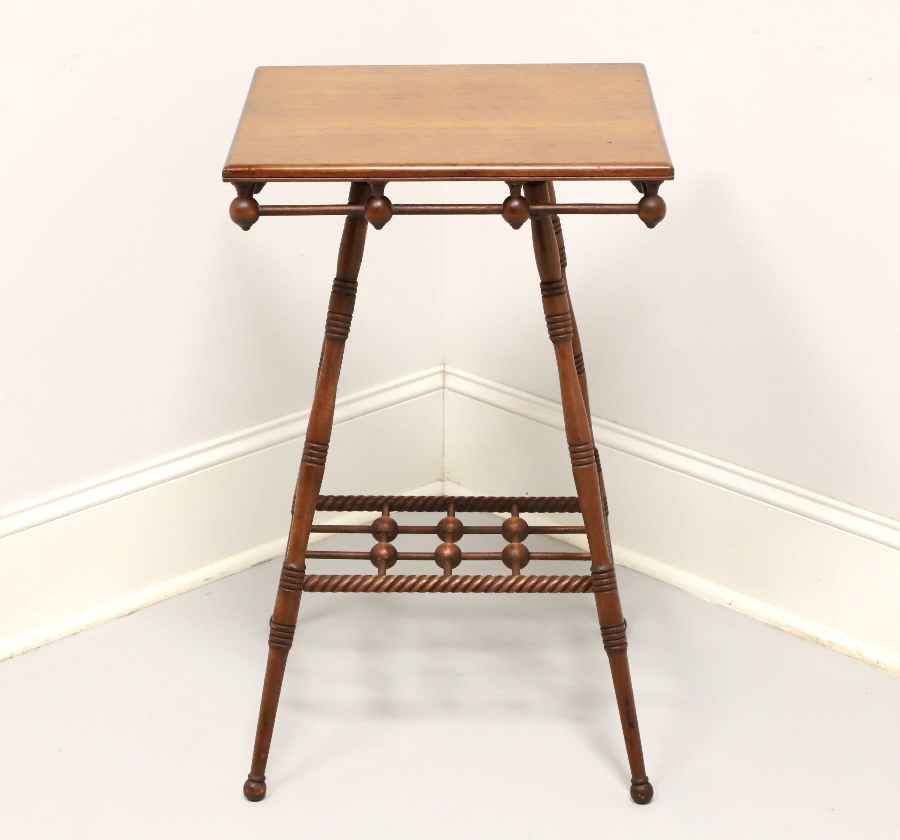 An antique square side table in the Victorian style, unbranded. Handcrafted of walnut, decorative apron, barley twist stretchers, open undertier, turned legs and ball feet. Features an open decorative wood connected reverse finial apron and barley