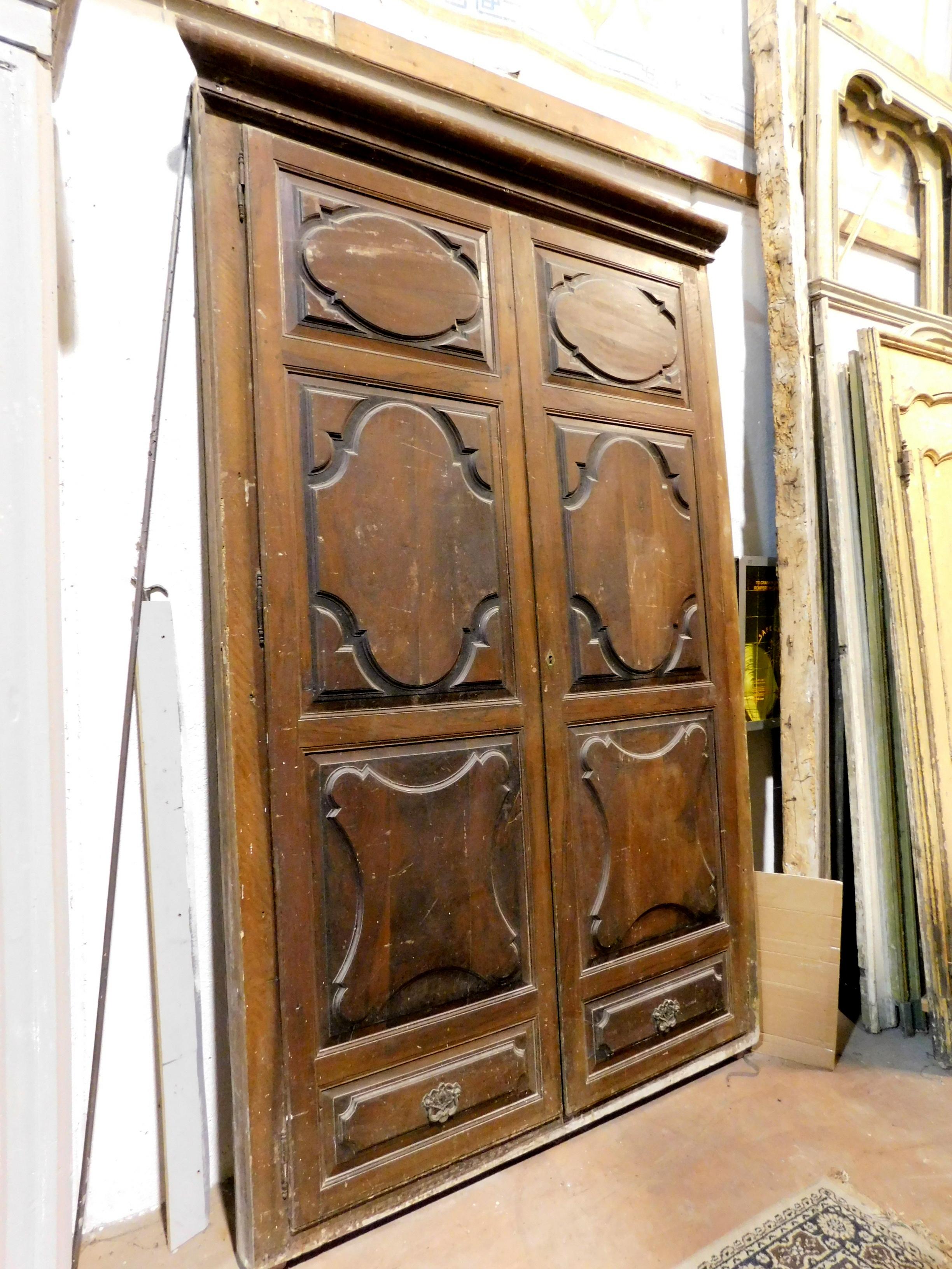 Antique walnut wall cabinet, hand-carved cupboard, consisting of two large doors and frame with hat, panels carved with Baroque tiles, in very sturdy solid walnut, built and sculpted entirely by hand in the 17th century, for wardrobes at home in