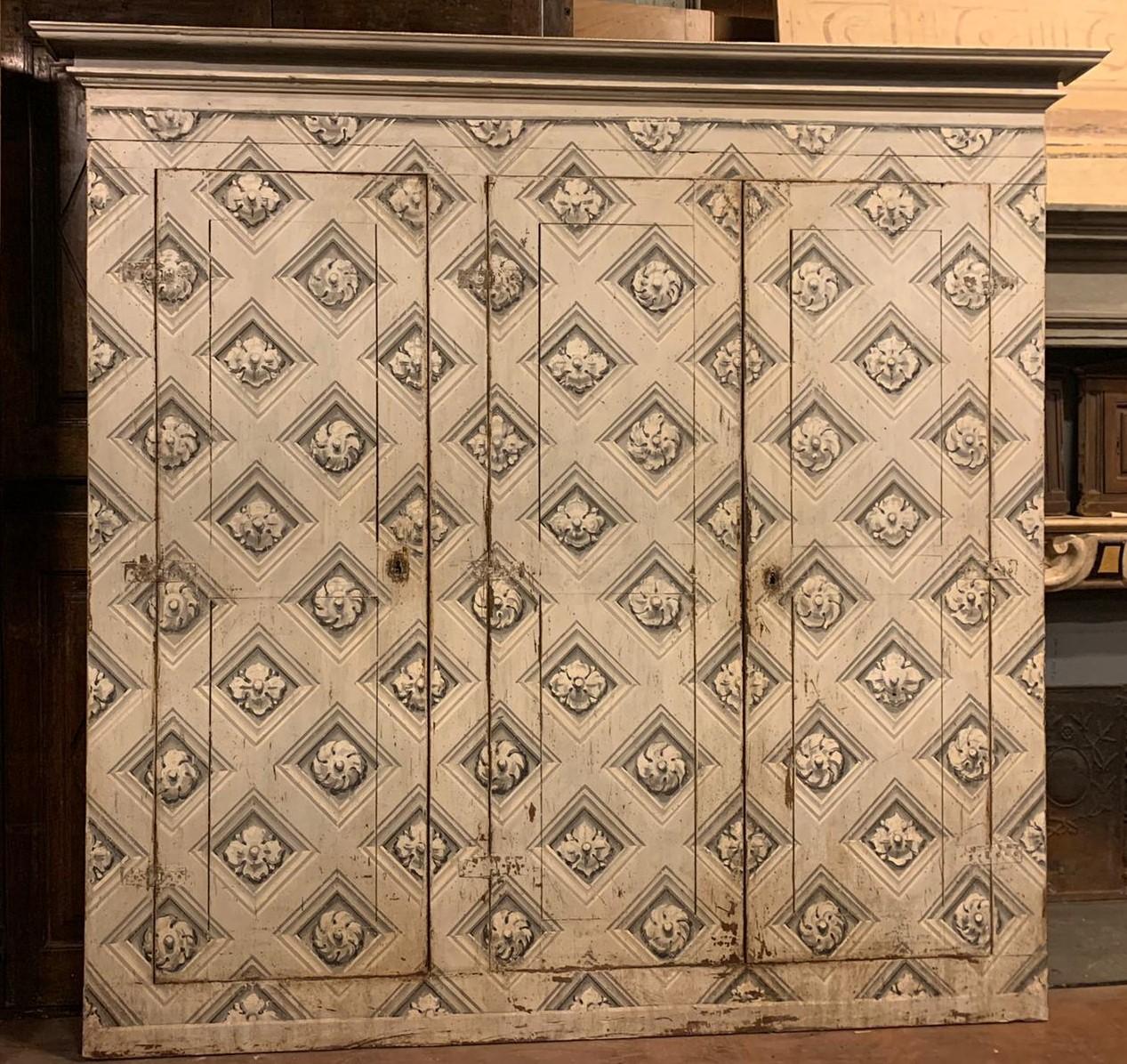 Antique walnut wall cabinet, placard, cupboard, hand painted with a repeating pattern of classic motifs (circular flower) in black and white, consisting of 3 wings that open to pull, handmade, carved, lacquered, in the era ' 700, from Piedmont