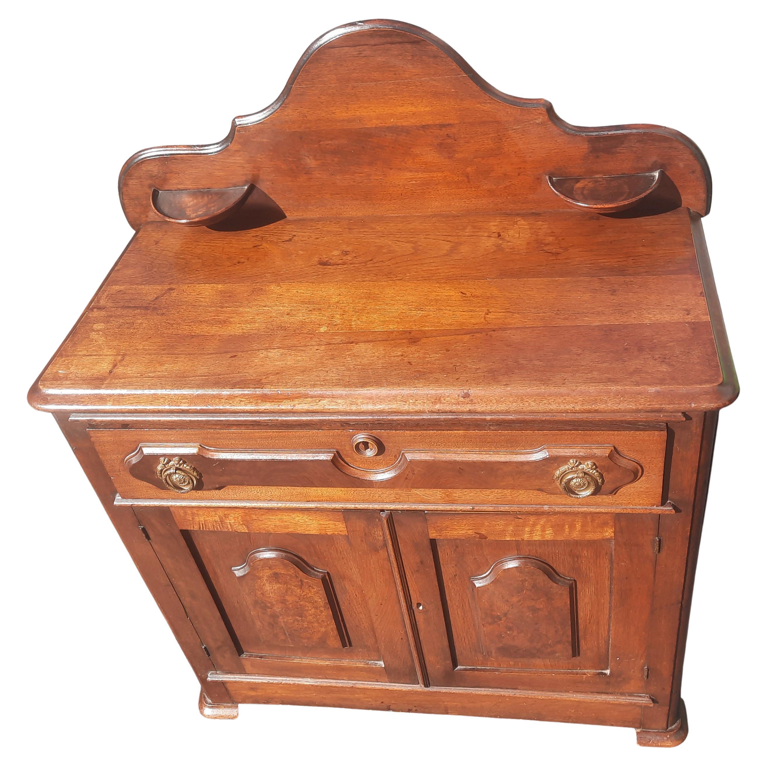 Antique walnut washstand with candle holder, soap holder and back splash 1 trimmed knapp joint drawer, 
 paneled doors. Circa 1870-90 without. Good condition. On wheels.
Wear appropriate with age and use, overall in good vintage