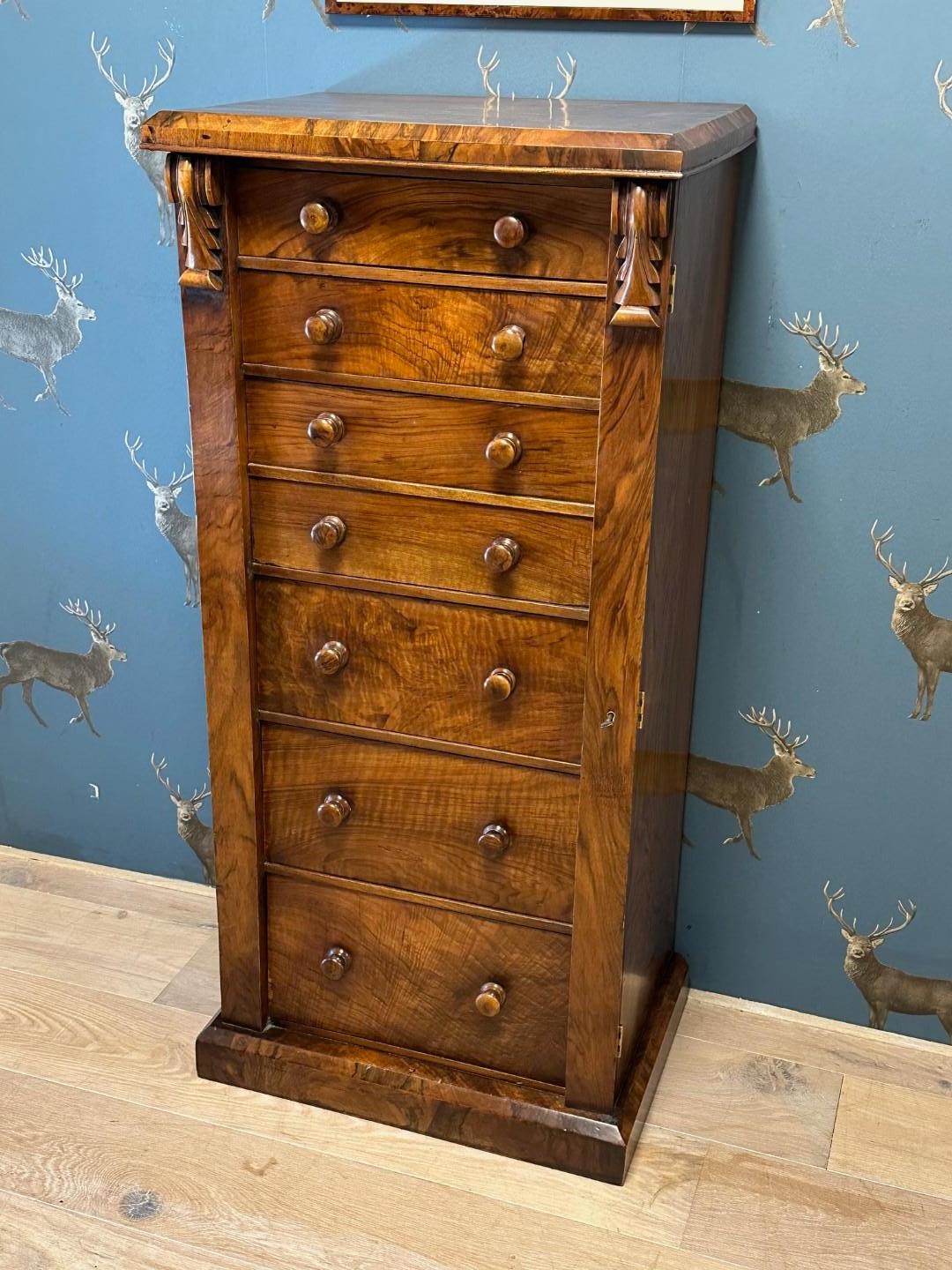 Belle commode ancienne Wellington en noyer avec secrétaire en bon état et tout à fait d'origine. Magnifique motif et couleur du noyer. Le tiroir secrétaire peut être utilisé comme un petit plan de travail mais aussi comme un tiroir pour ranger des