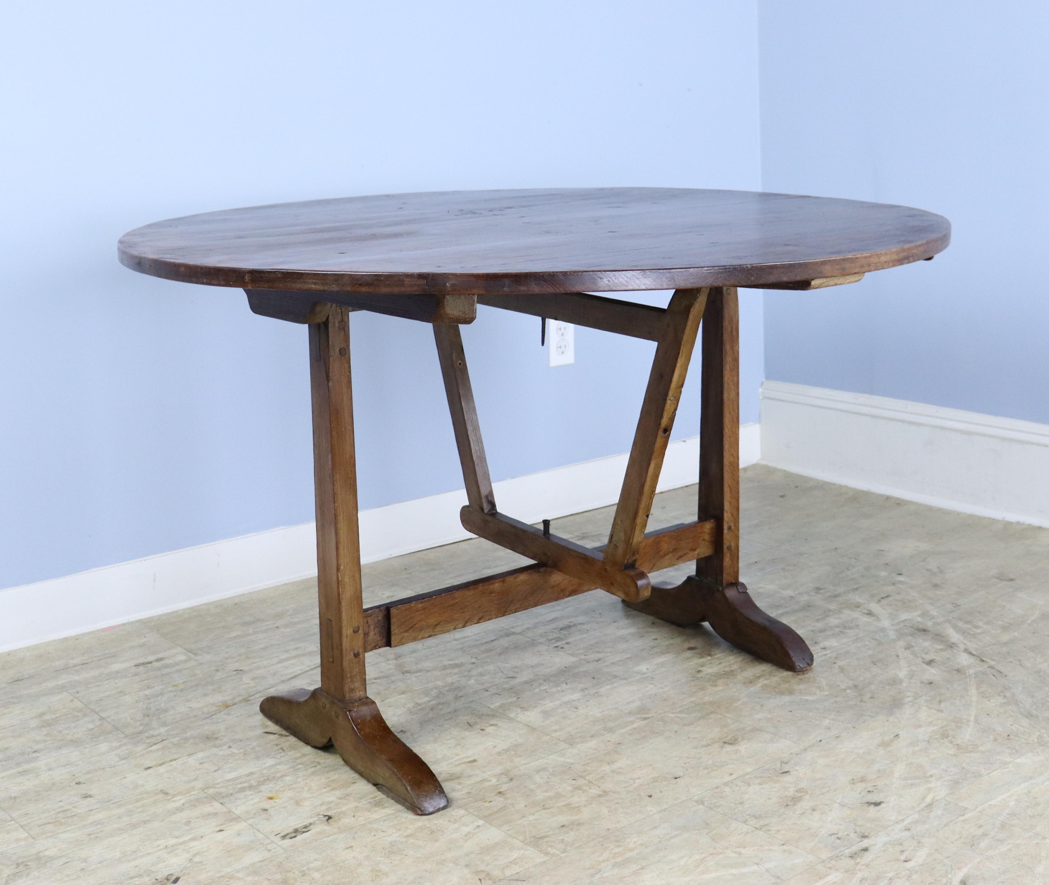 The walnut graining on this very good vendange wine tasting table is smooth and consistent. The top has a nice patinated edge. The swivel gateleg table base is easy to use and is sturdy. The table can be stored upright if required, but would be a
