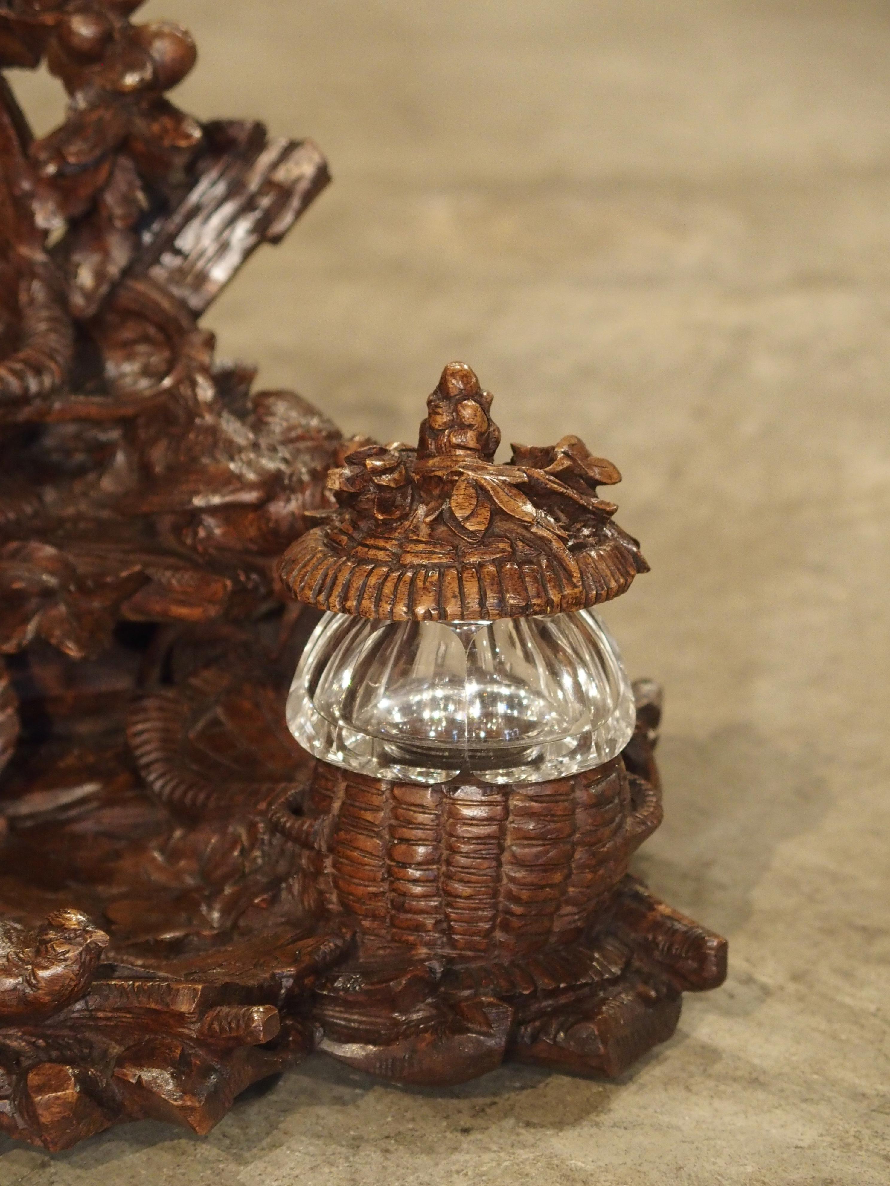 This stunning antique Black Forest inkwell has been made from walnut wood and dates to circa 1900. The piece is composed of carved twigs, leaves, berries, rocks and five little birds. Toward the top of the inkwell, is a small wicker basket with a
