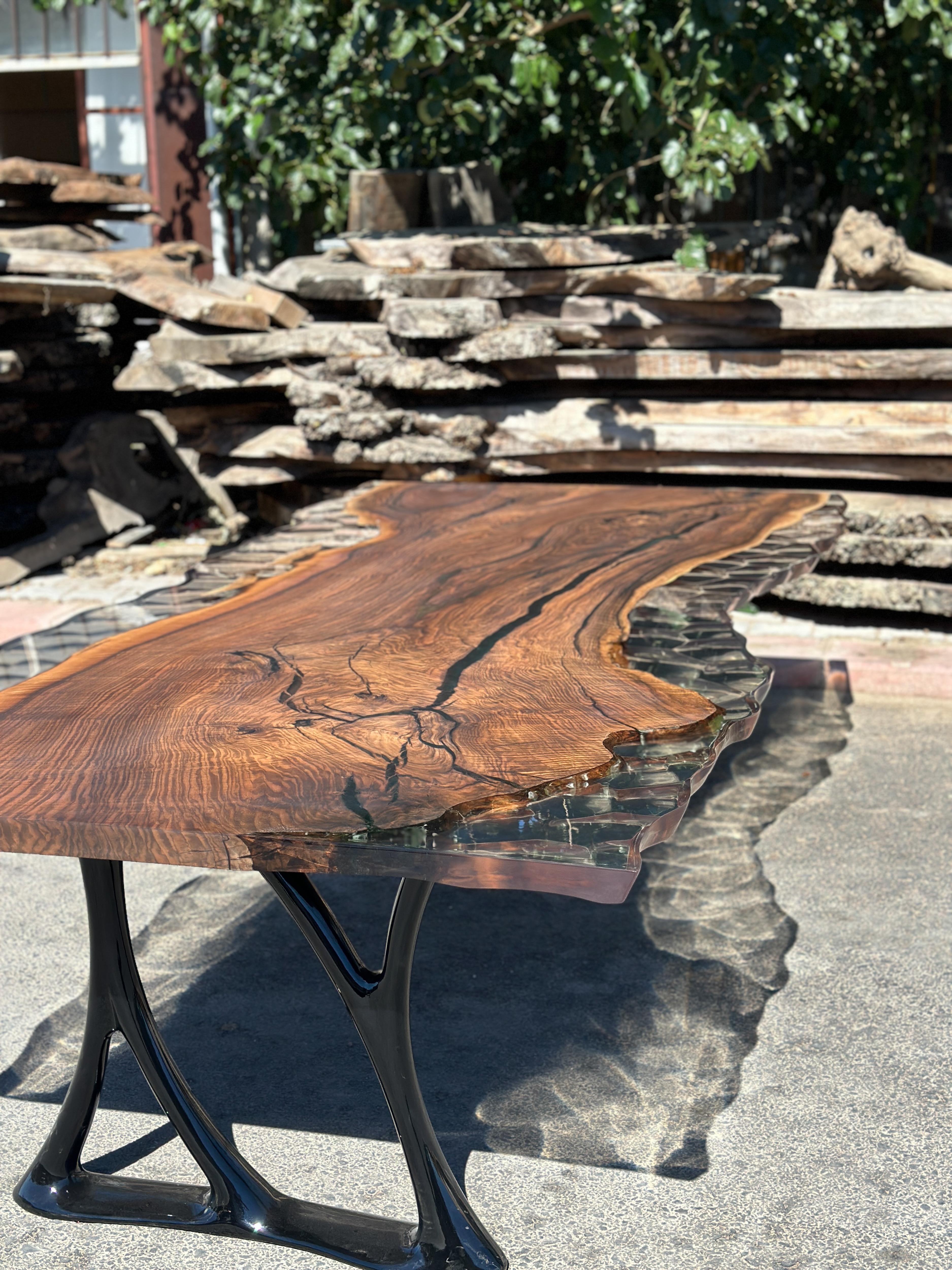 Mesa de comedor de resina epoxi transparente personalizada en nogal negro 

Esta mesa está hecha con madera de nogal de 800 años de antigüedad. Las vetas y la textura de la madera describen el aspecto de un nogal natural.
Puede utilizarse como mesa