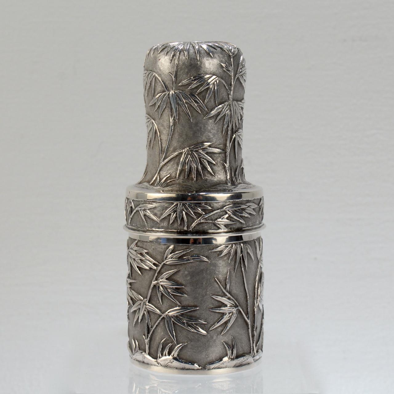A fine antique Chinese Export silver cased travel dresser bottle.

The interior housing is an English glass dresser bottle with a stopper.

The exterior consisting of a hand made conforming thread base and cover. Decorated with high relief bamboo