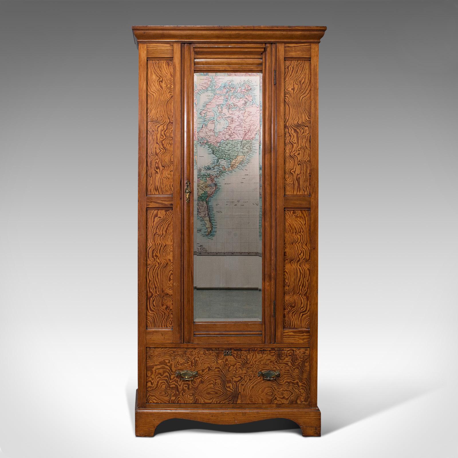 This is an antique wardrobe. An English, pitch pine closet with bevelled dressing mirror, dating to the late Victorian period, circa 1900.

Extravagant figuring presents a highly distinctive appeal
Displaying a desirable aged patina and in good