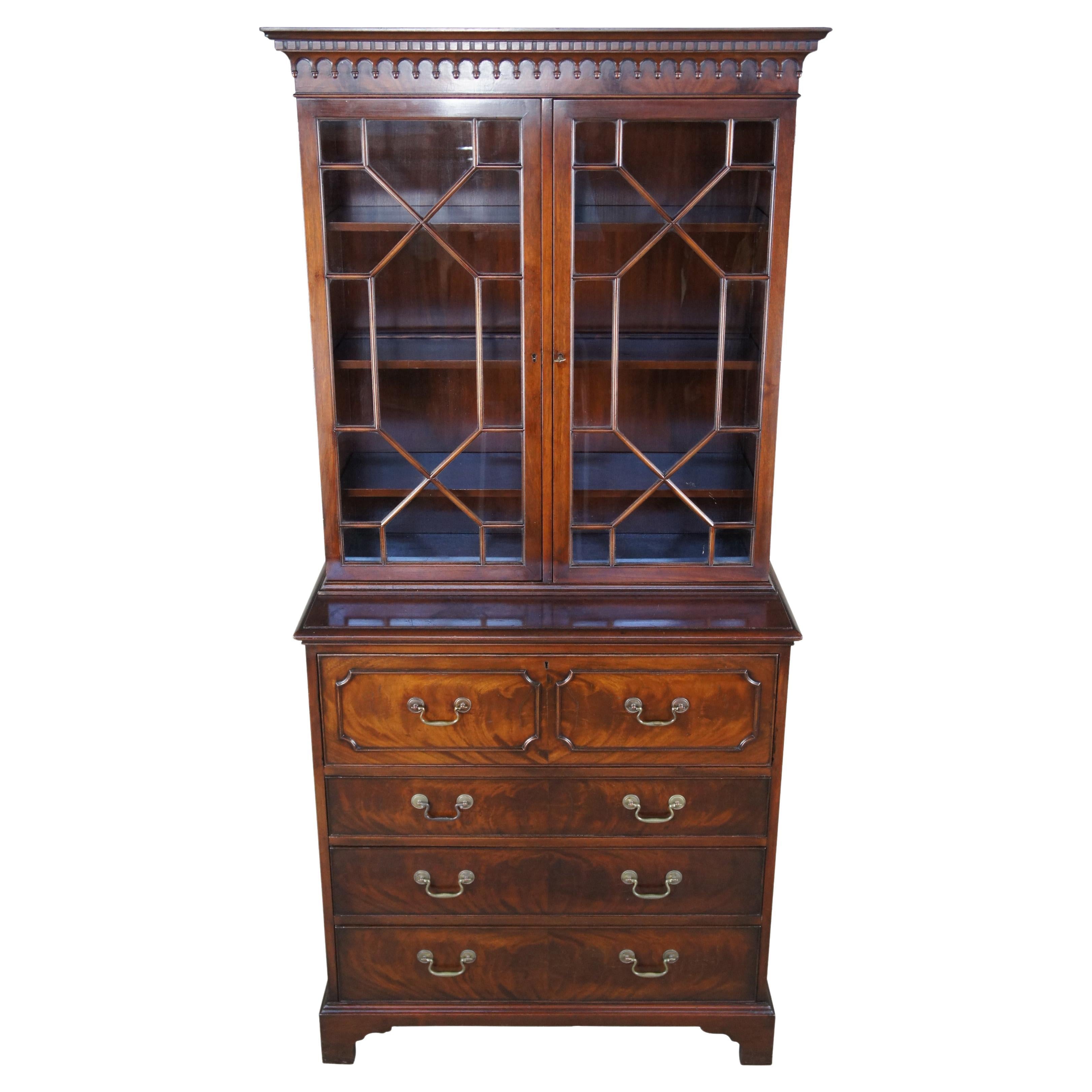 Antique Warsaw Furniture Mfg Co Federal or Georgian stepback butlers secretary desk and bookcase. Made of flamed mahogany with upper bookcase cabinet that features fretwork glass doors and dentil crown with arcade molding. The lower lower secretary