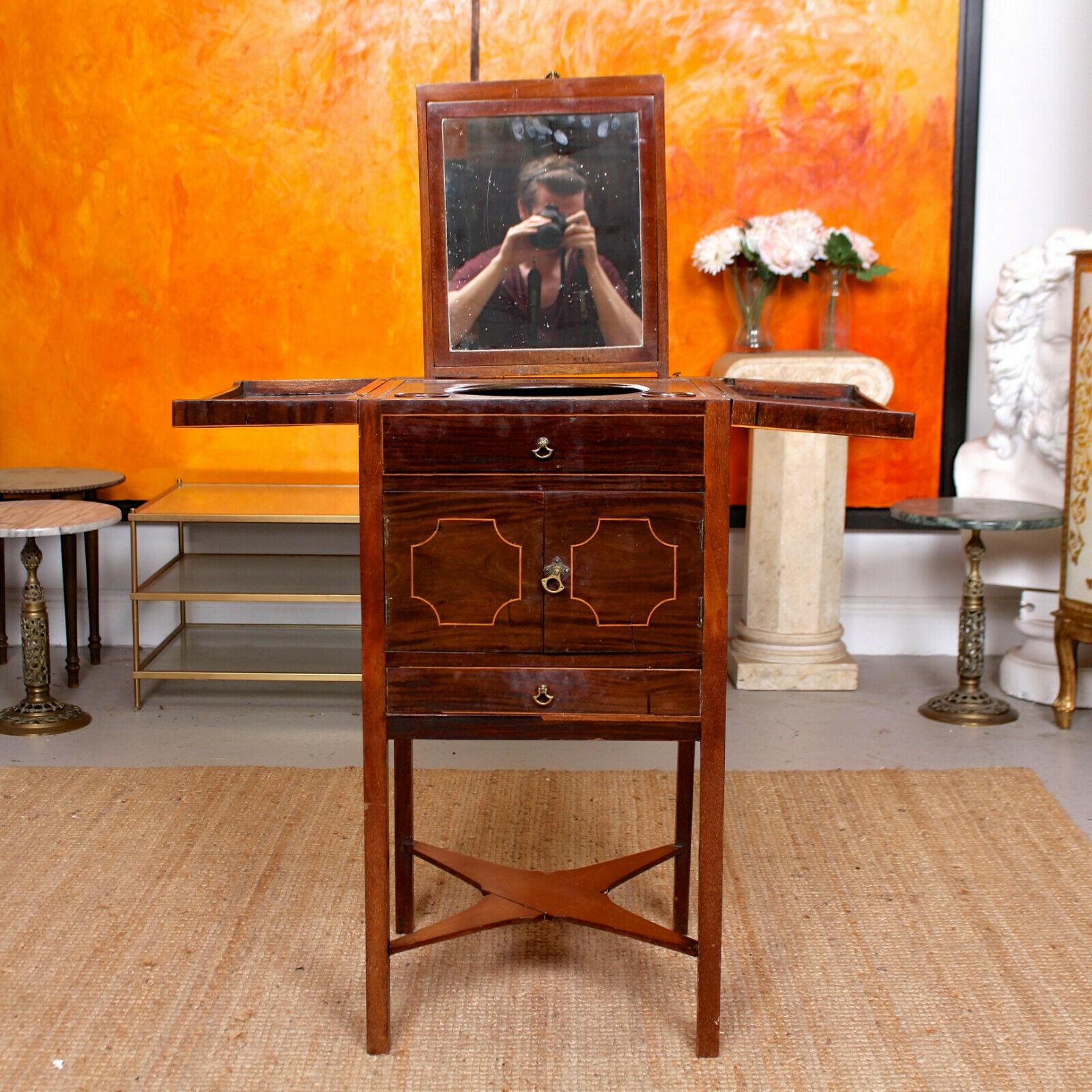 An impressive and rare form late 18th century mahogany and boxwood shaving washstand.

The hinged top enclosed height adjustable swing mirror, washbow cutout and fitted compartments above a pair of doors enclosed storage and fitted drawer. Raised