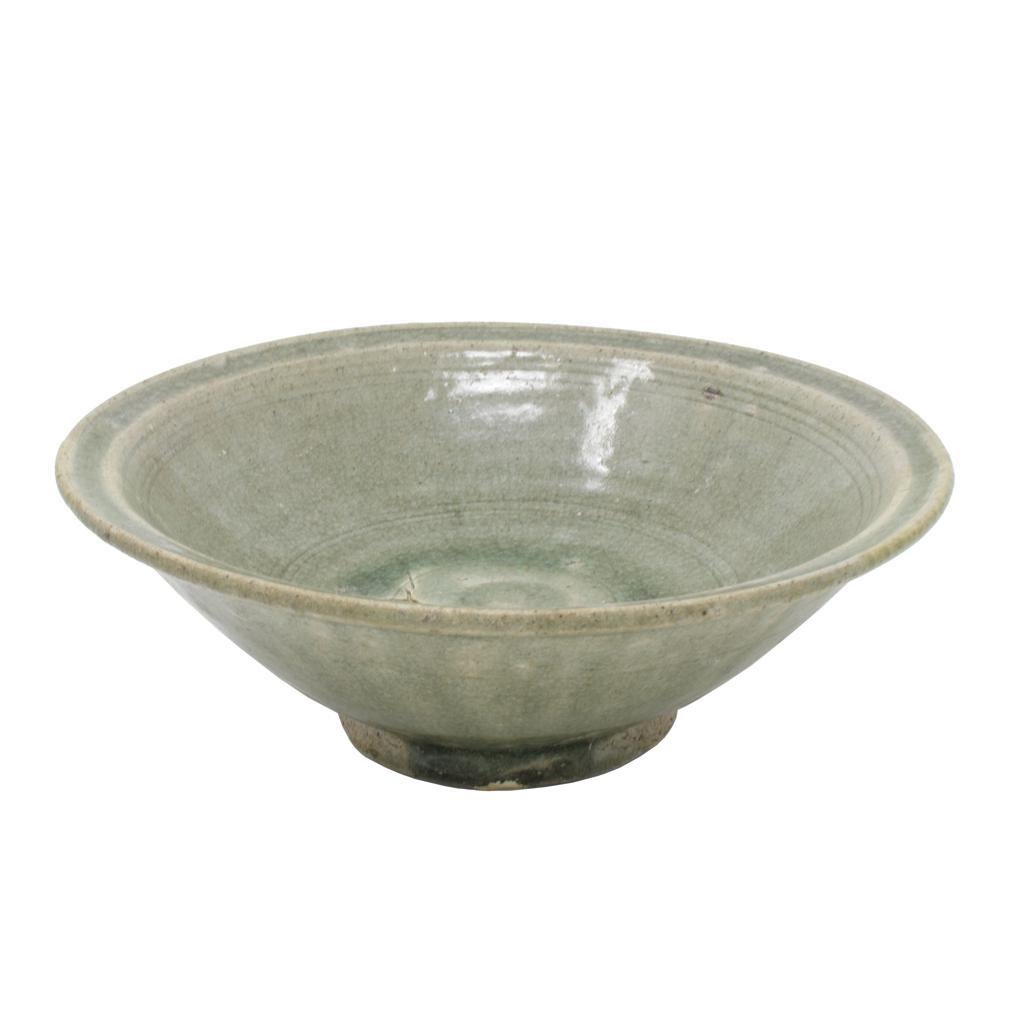 Antique “Waster” Celadon Bowl, Sawankhalok kilns, Thailand, 14th/15th century.
A thickly potted wheel thrown stoneware bowl with everted rim having an upturned lip. The cavetto with incised lines.  The outside wall has some incised bands but is